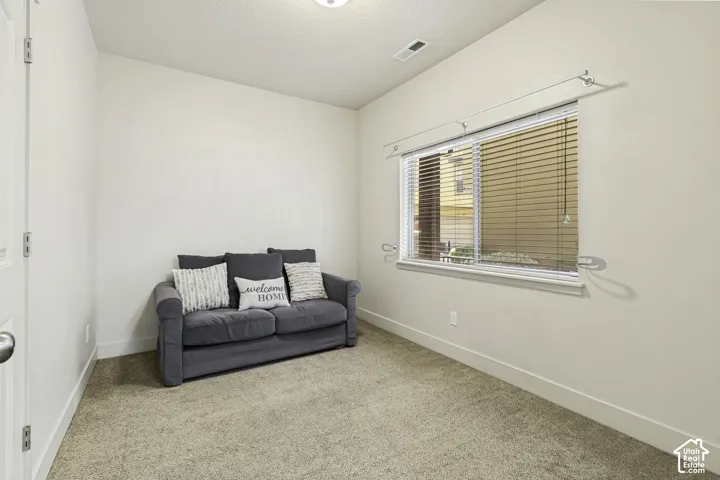 Carpeted room with a single window featuring horizontal blinds