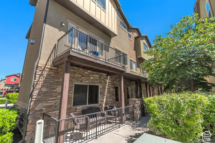 Multi-story townhome exterior featuring stone veneer and stucco siding