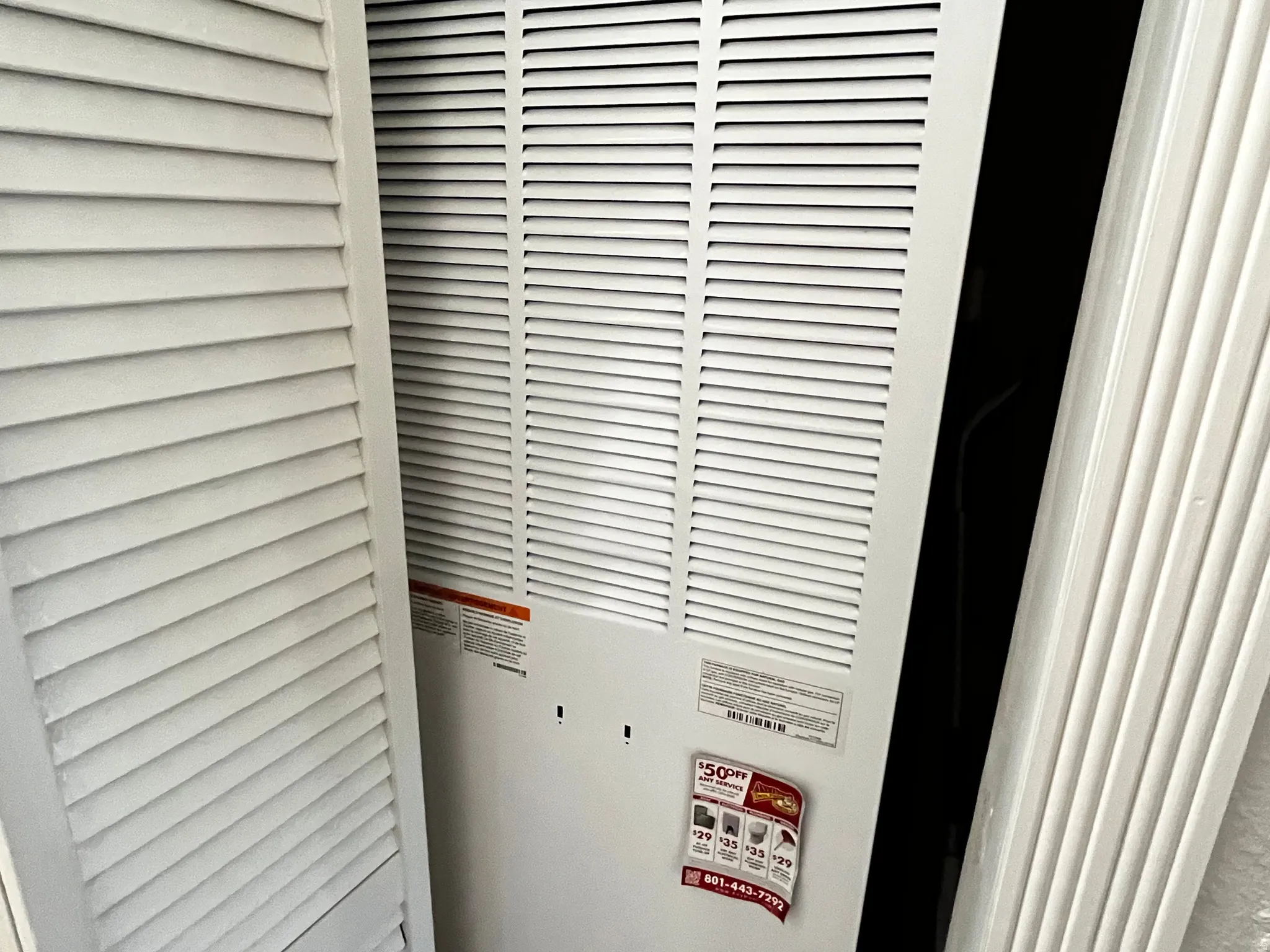 Louvered bi-fold doors conceal a utility area featuring a white louvered HVAC return air vent
