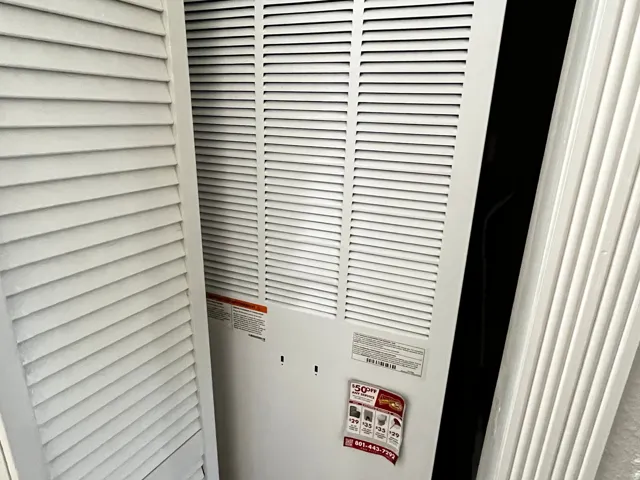 Louvered bi-fold doors conceal a utility area featuring a white louvered HVAC return air vent