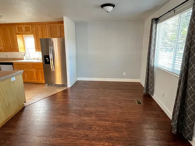 Spacious interior featuring wood-finish flooring and a large window with blinds