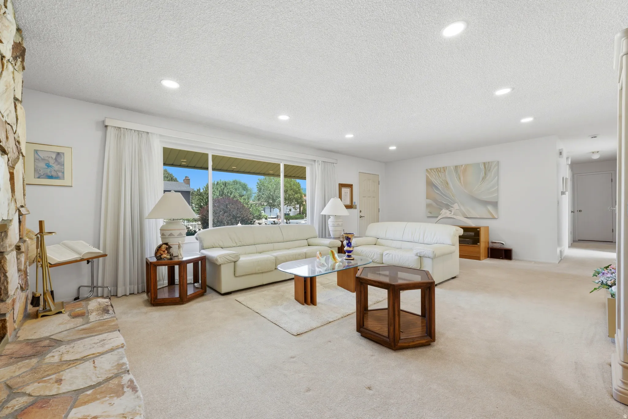 Spacious living area featuring a stone-clad fireplace and hearth