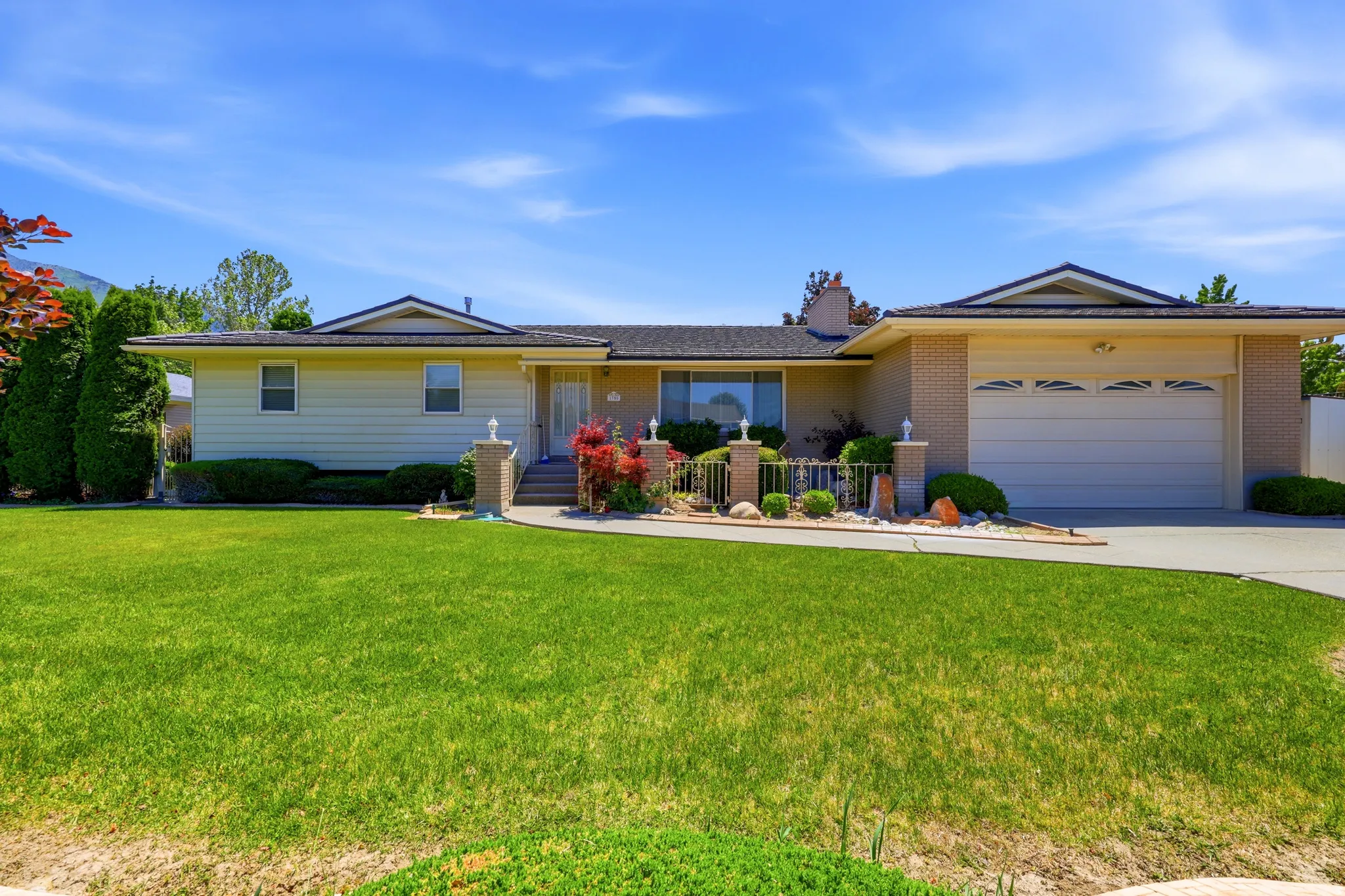 Ranch-style residence featuring a brick facade, attached two-car garage, and a concrete driveway