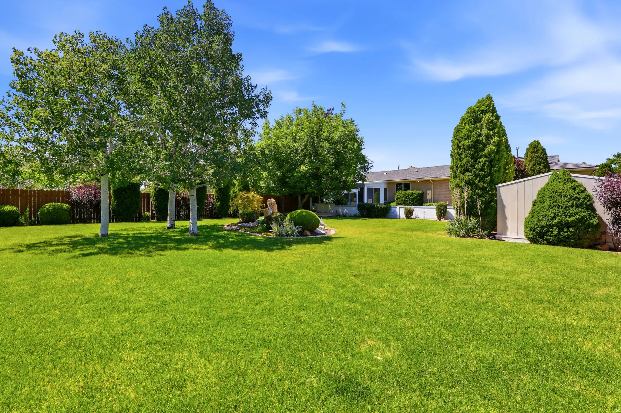 Expansive lawn with mature trees and landscaping