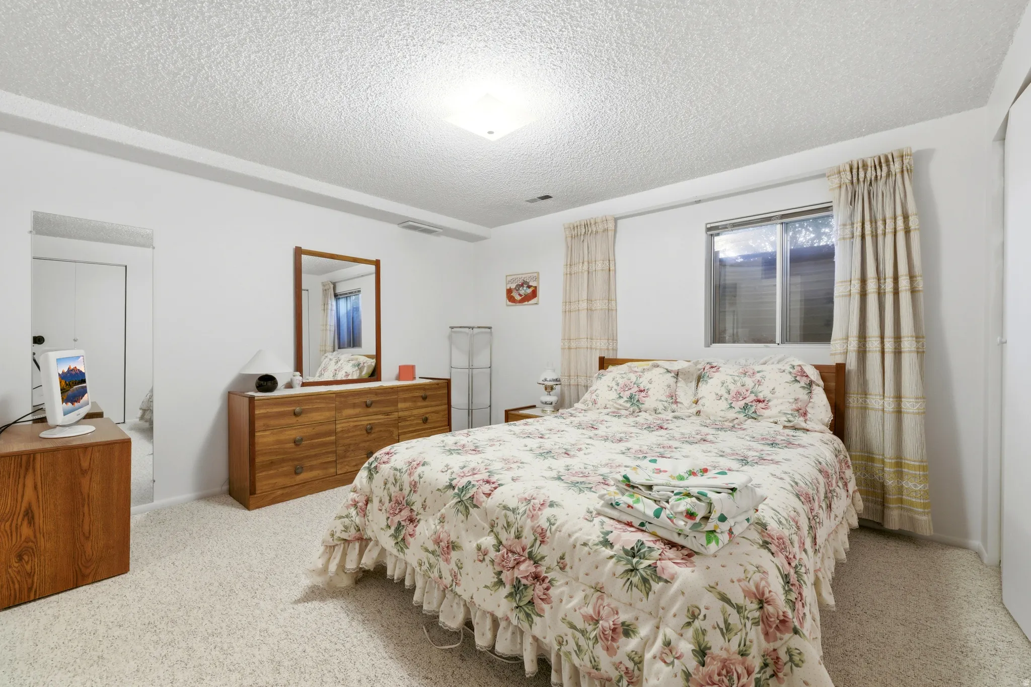 Carpeted room with a textured ceiling and white walls