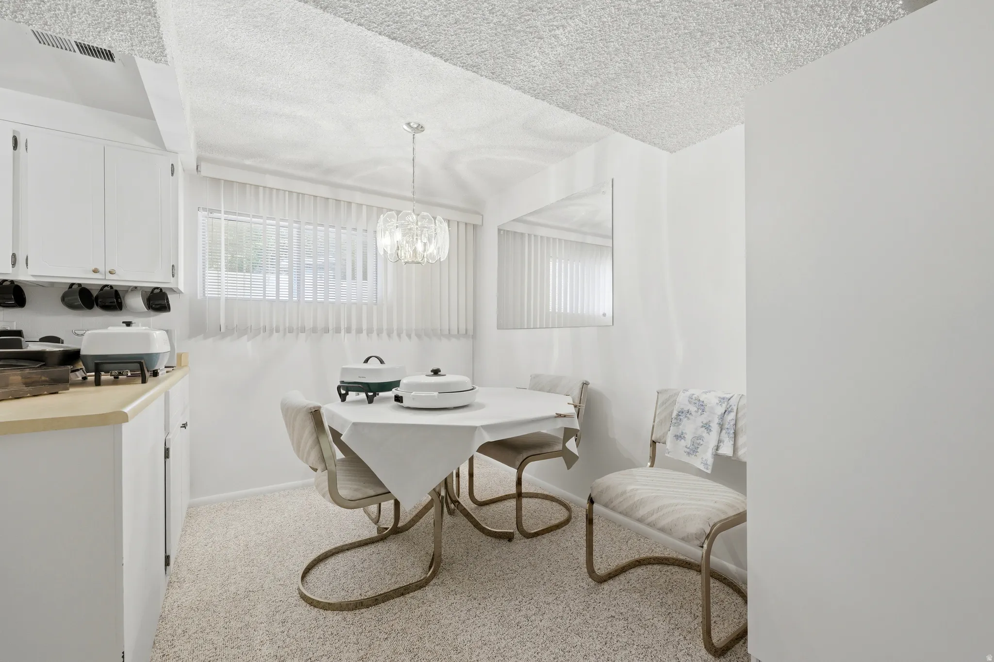 Dining area featuring wall-to-wall carpeting and a decorative chandelier