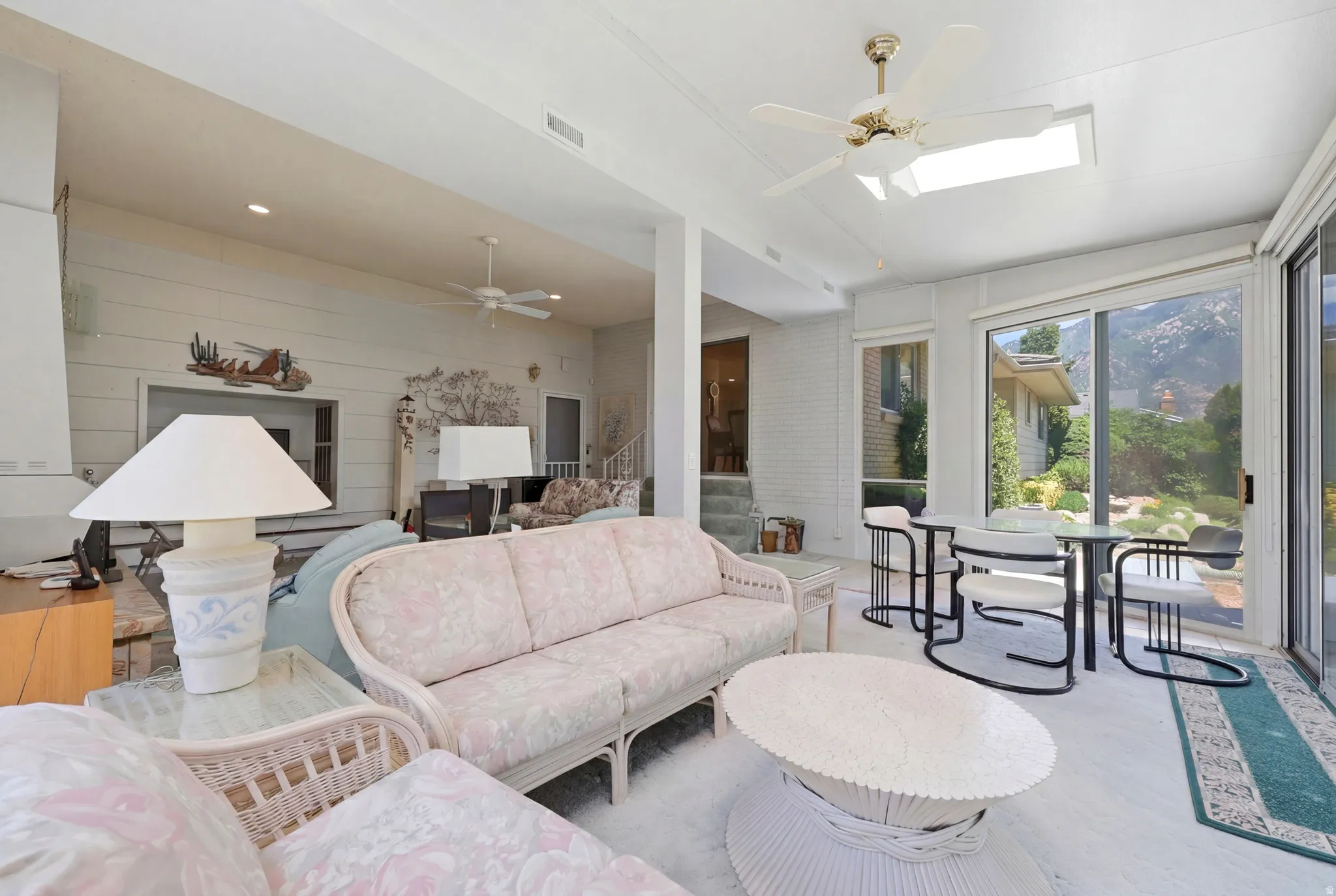 Sunroom area with a high vaulted ceiling, large sliding glass doors, and skylight