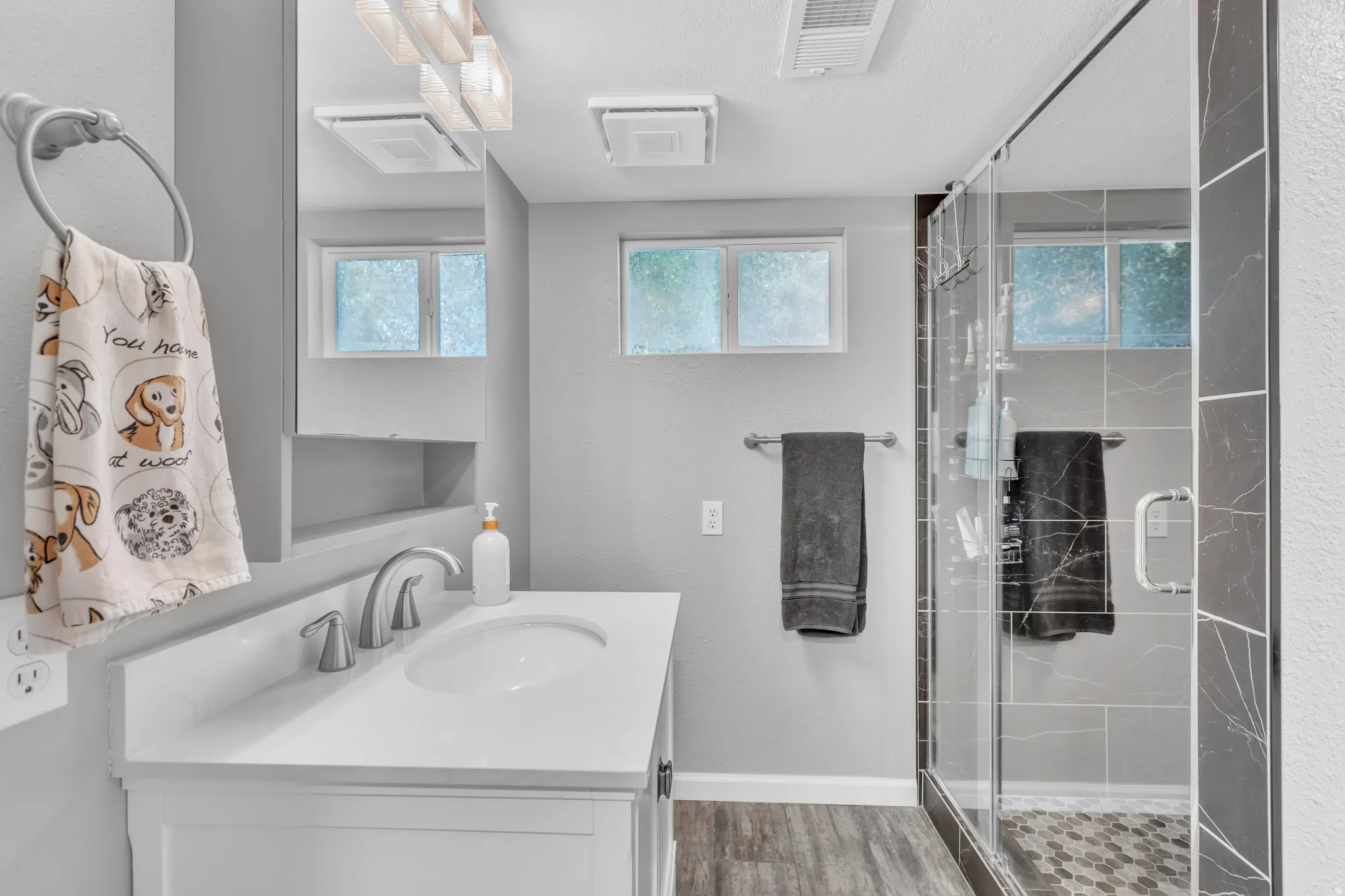 Modern bathroom featuring a white vanity with integrated sink, brushed nickel faucet, and a large framed mirror