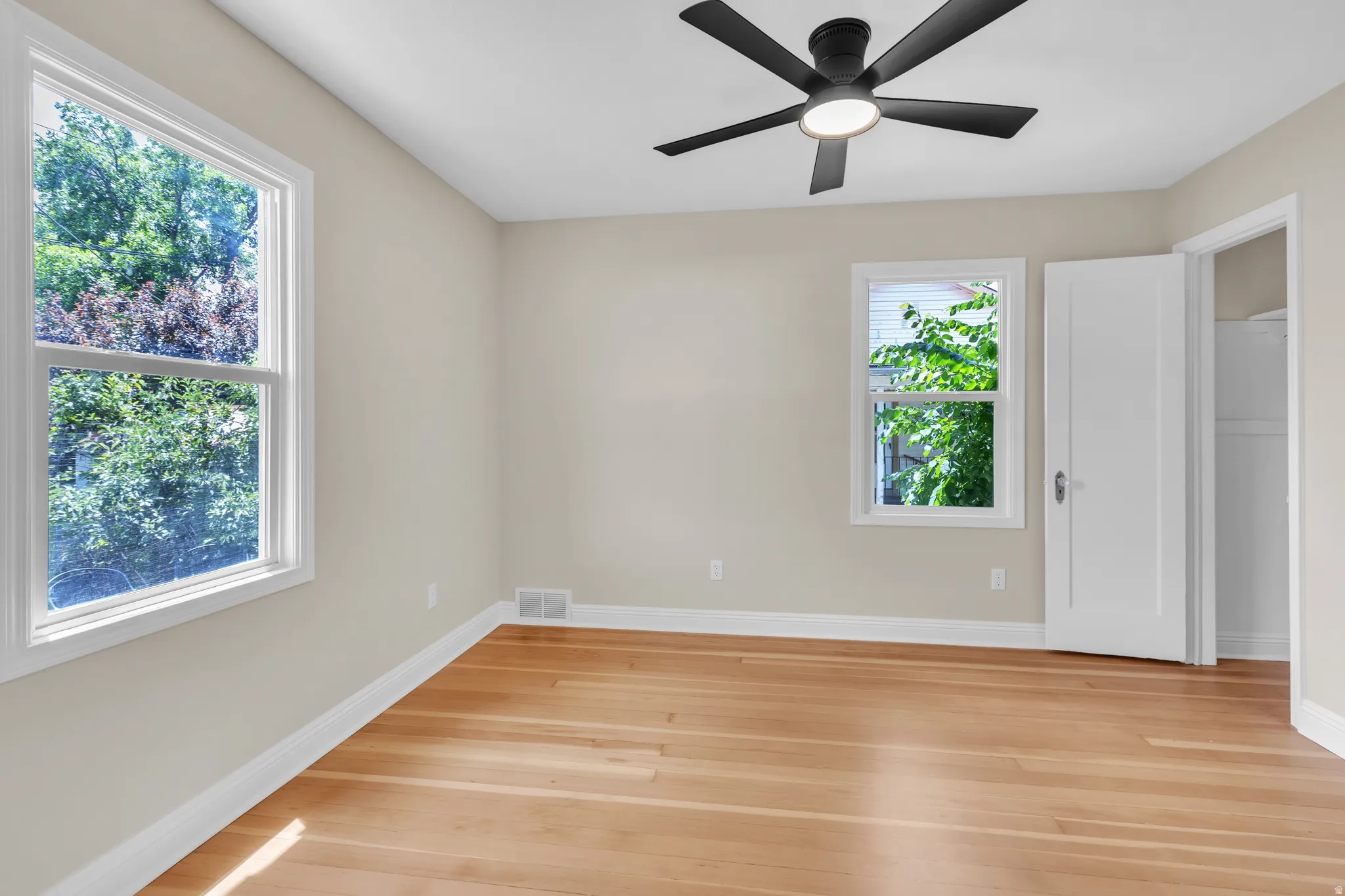Room featuring wood-finish flooring, neutral painted walls, and white trim