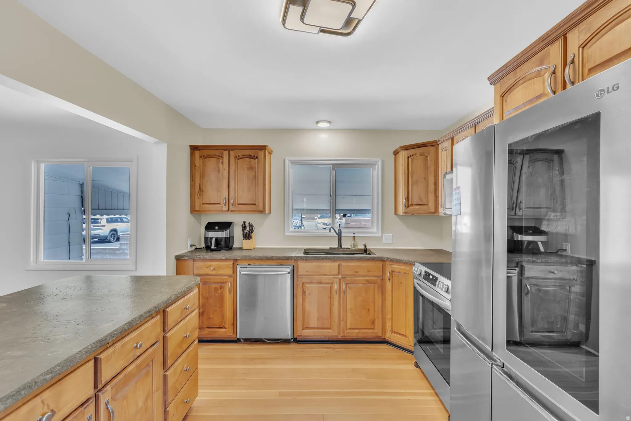 Kitchen featuring wood cabinetry, stainless steel appliances, and wood-finish flooring