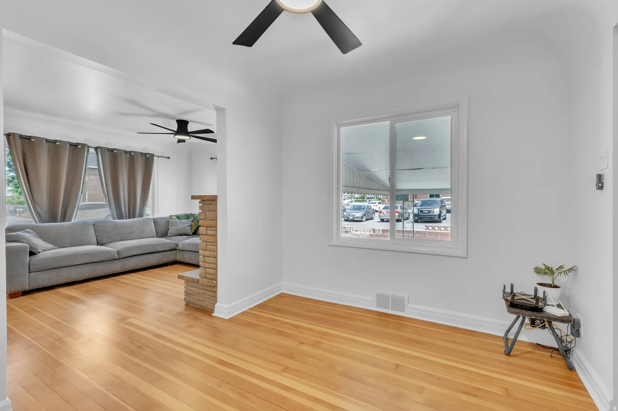 Hardwood-finish flooring throughout, featuring a stone-clad half-wall partition and a contemporary ceiling fan with integrated lighting