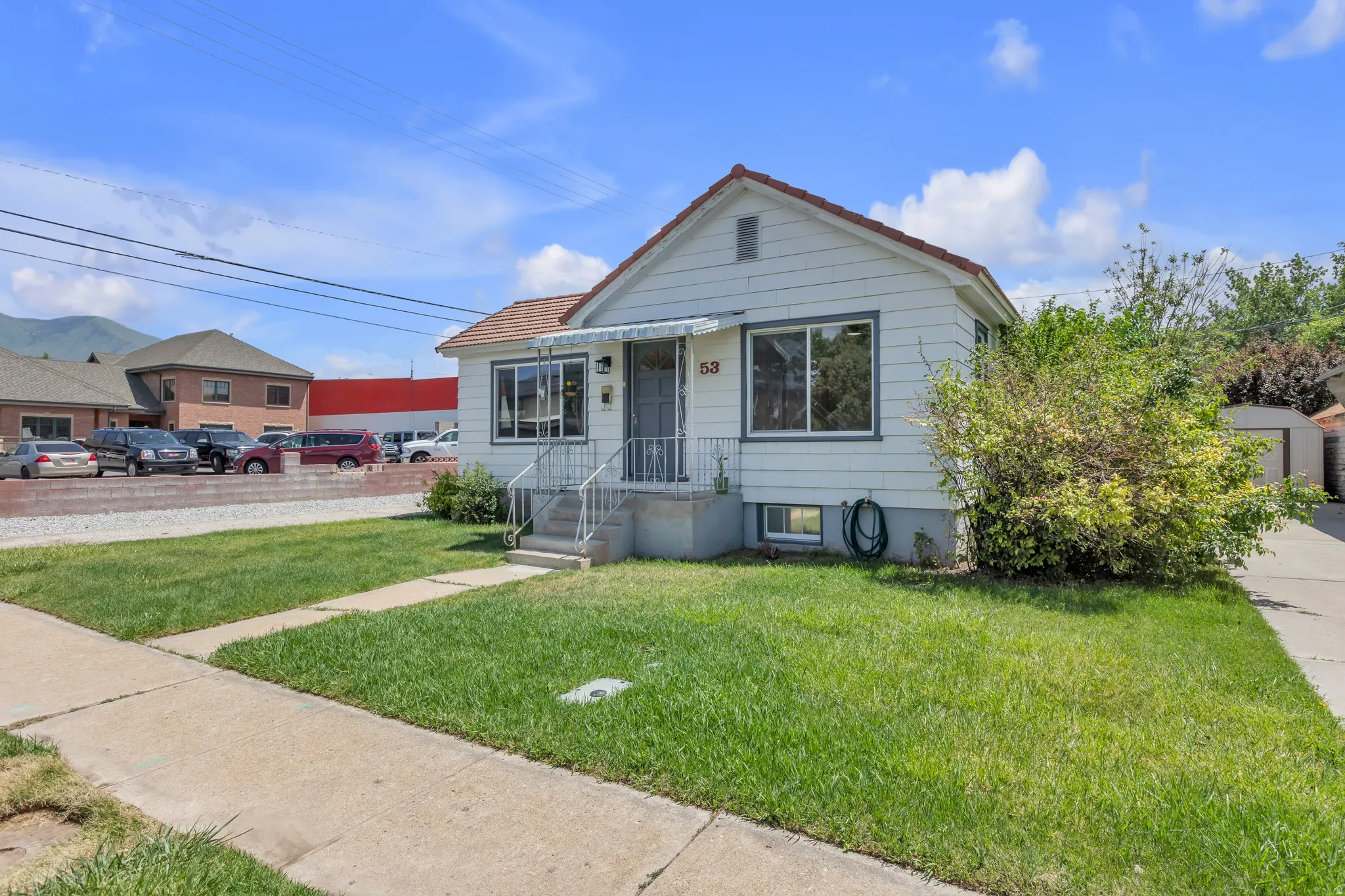 White siding exterior with a red tile roof