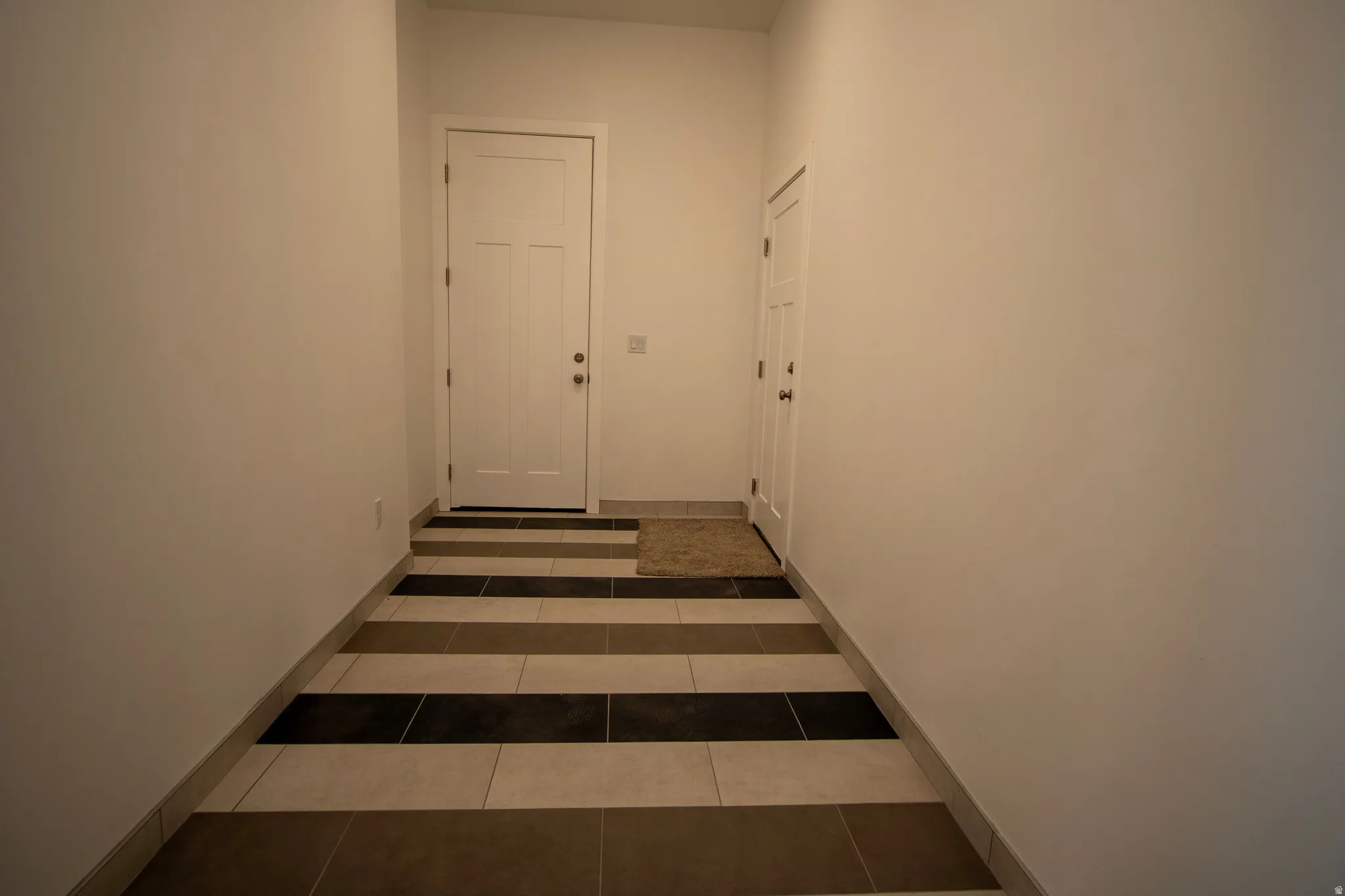Entryway with striped tile flooring and a neutral color palette
