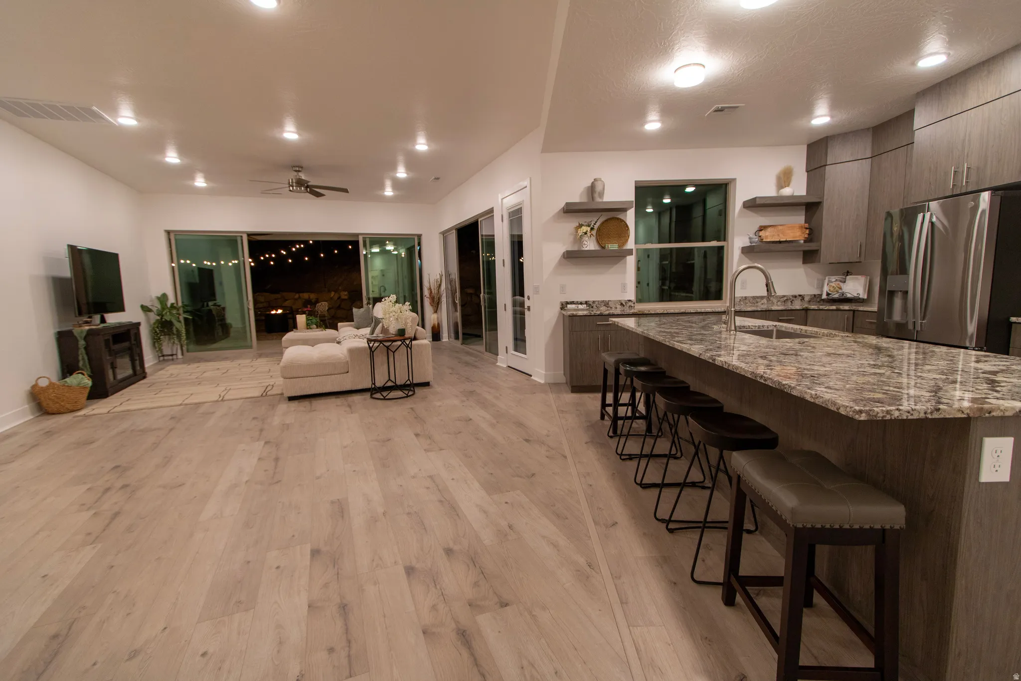Open-concept living area featuring wood-finish flooring, recessed lighting, and a ceiling fan