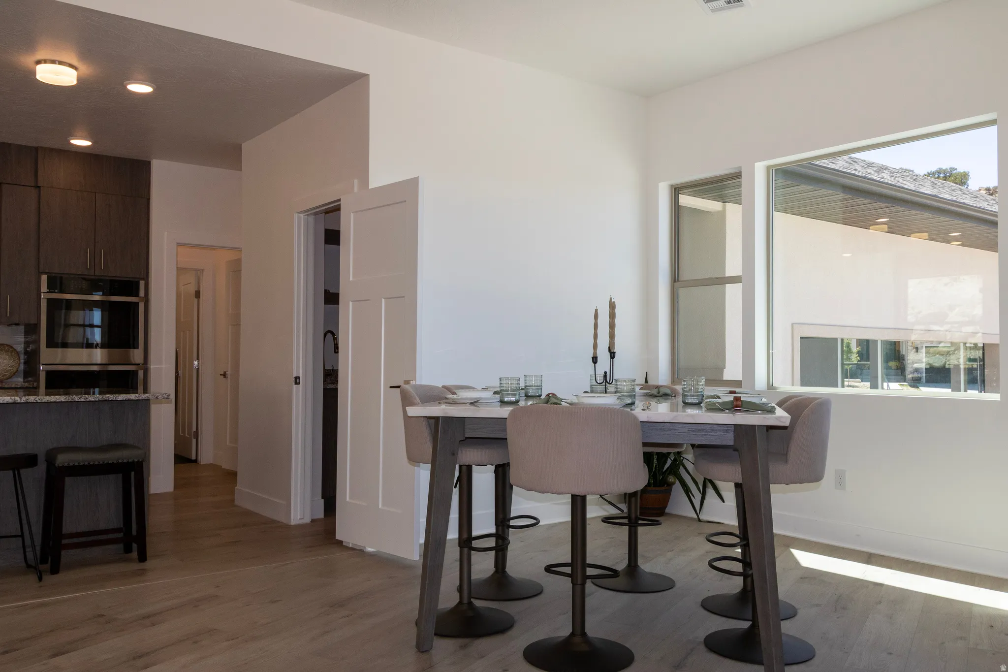 Open-concept dining area featuring light wood-finish flooring, a contemporary window design, and recessed lighting