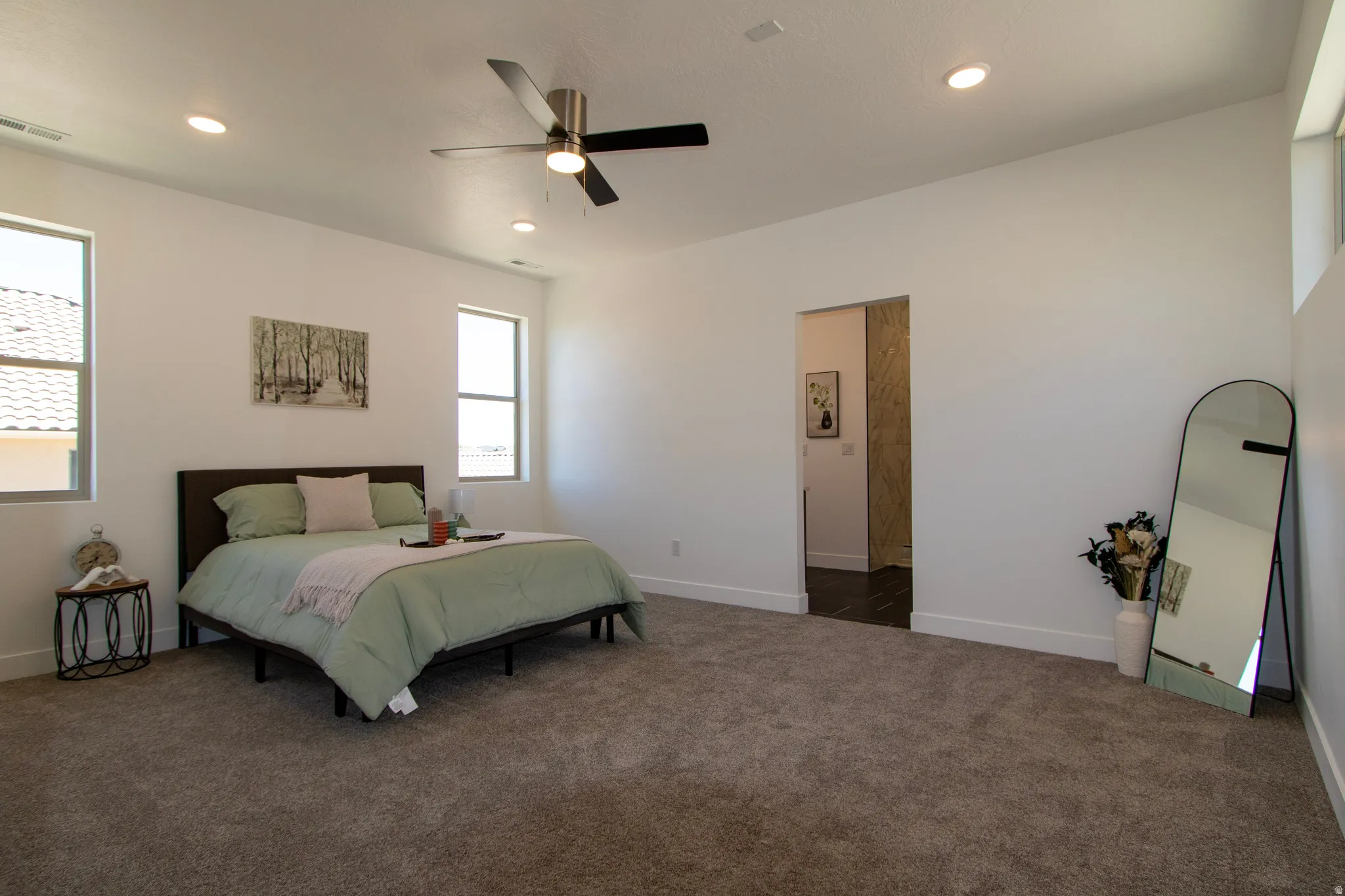 Spacious bedroom featuring plush carpet flooring, recessed lighting, and a modern ceiling fan