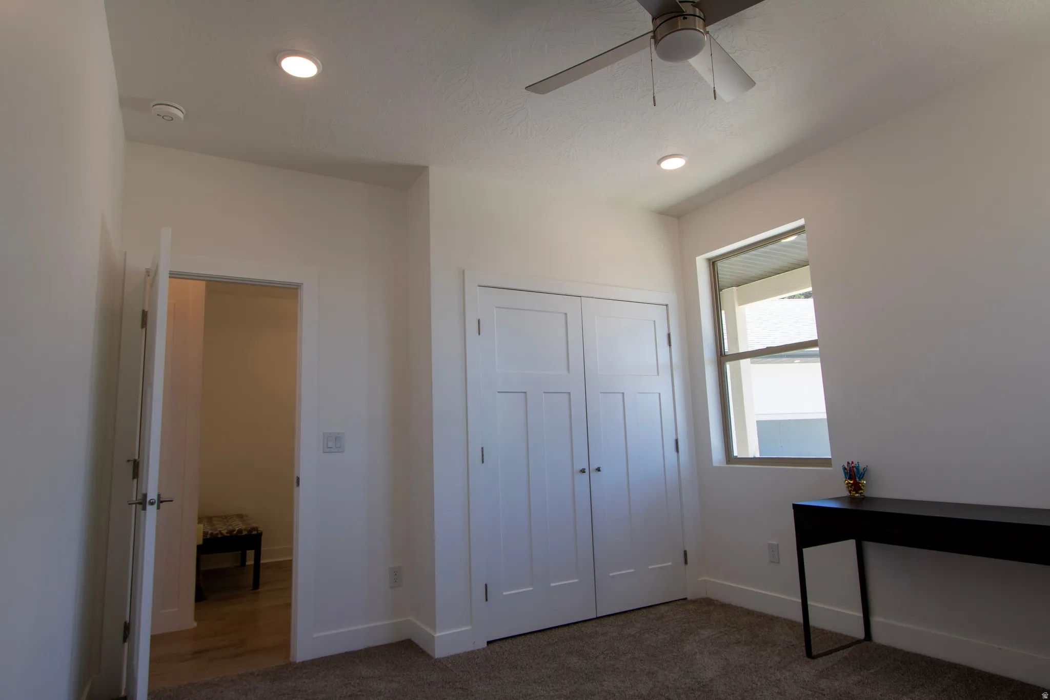 Room featuring neutral-toned walls, recessed lighting, a ceiling fan, and a single window