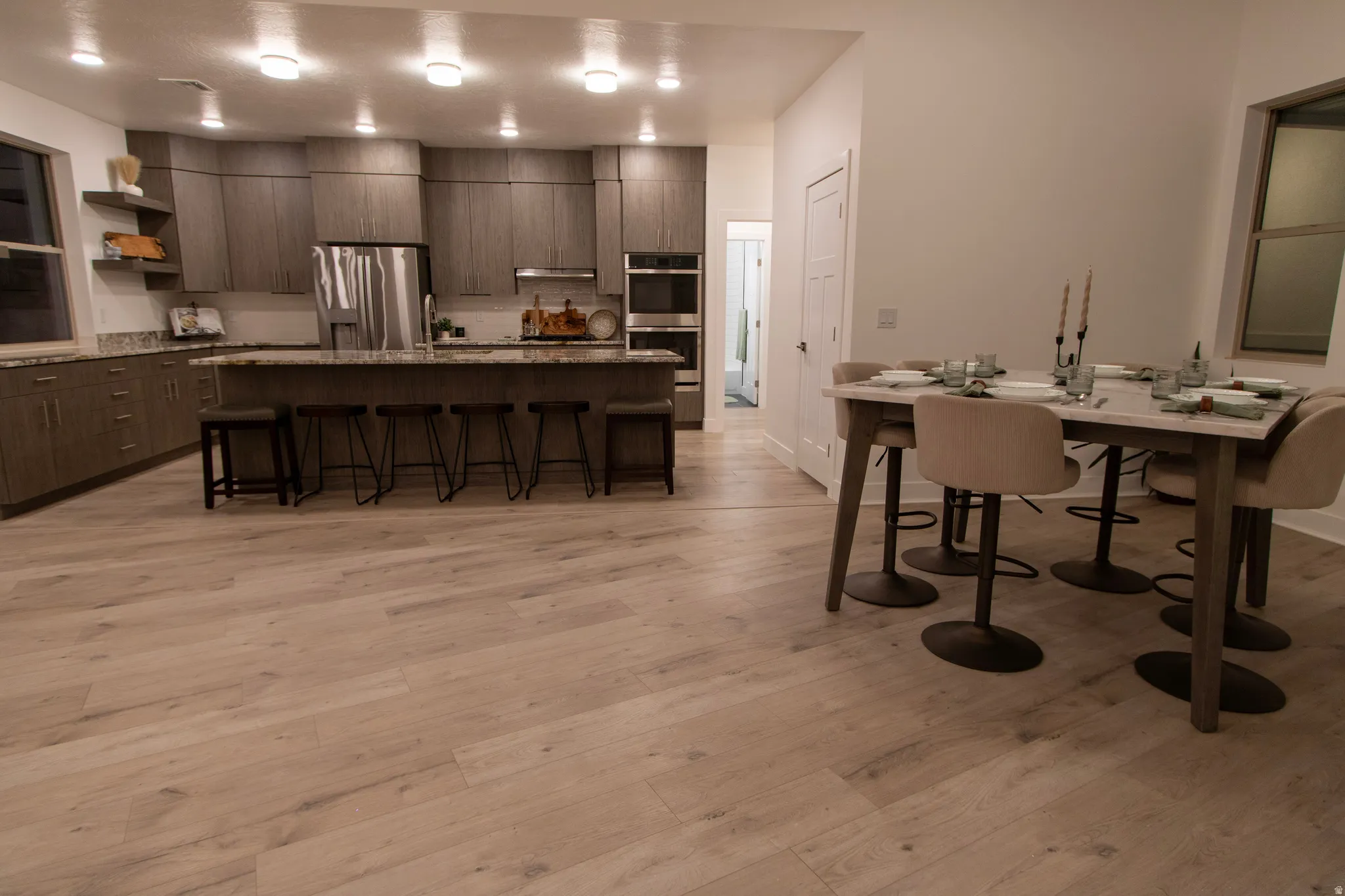 Spacious kitchen featuring gray cabinetry, stainless steel appliances, and a central island with bar seating