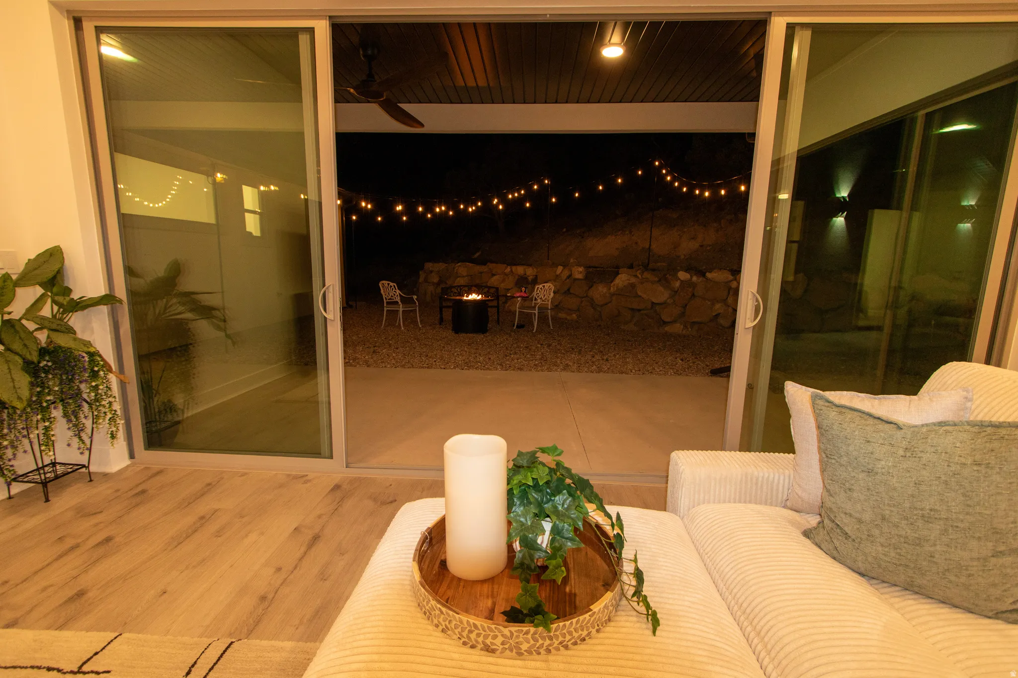 Sliding glass doors opening to an outdoor patio with string lights