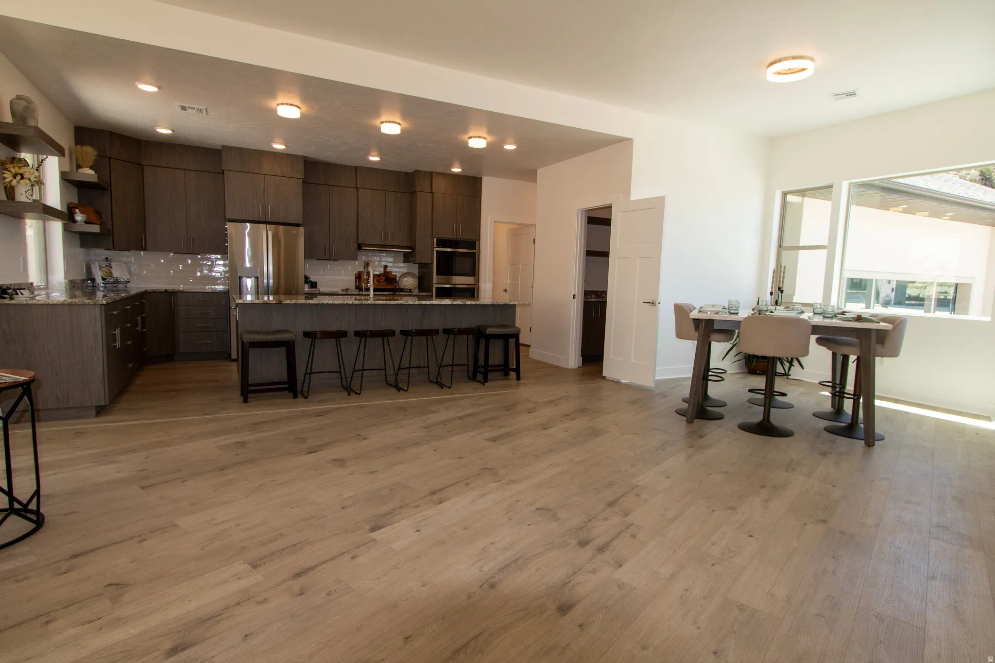 Open-concept kitchen and dining area featuring light wood-finish flooring