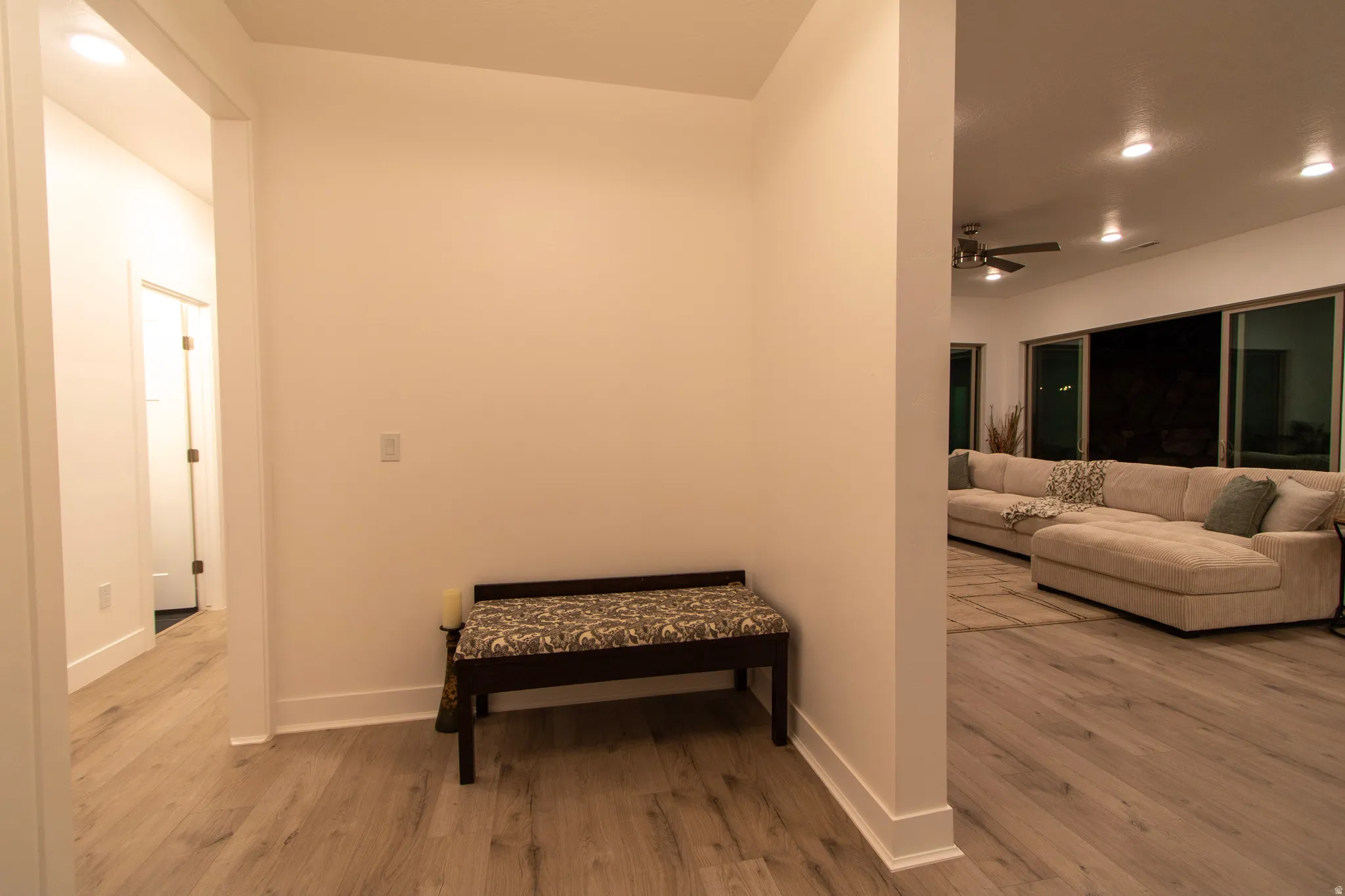 Open-concept living area with wood-finish flooring, recessed lighting, and a ceiling fan