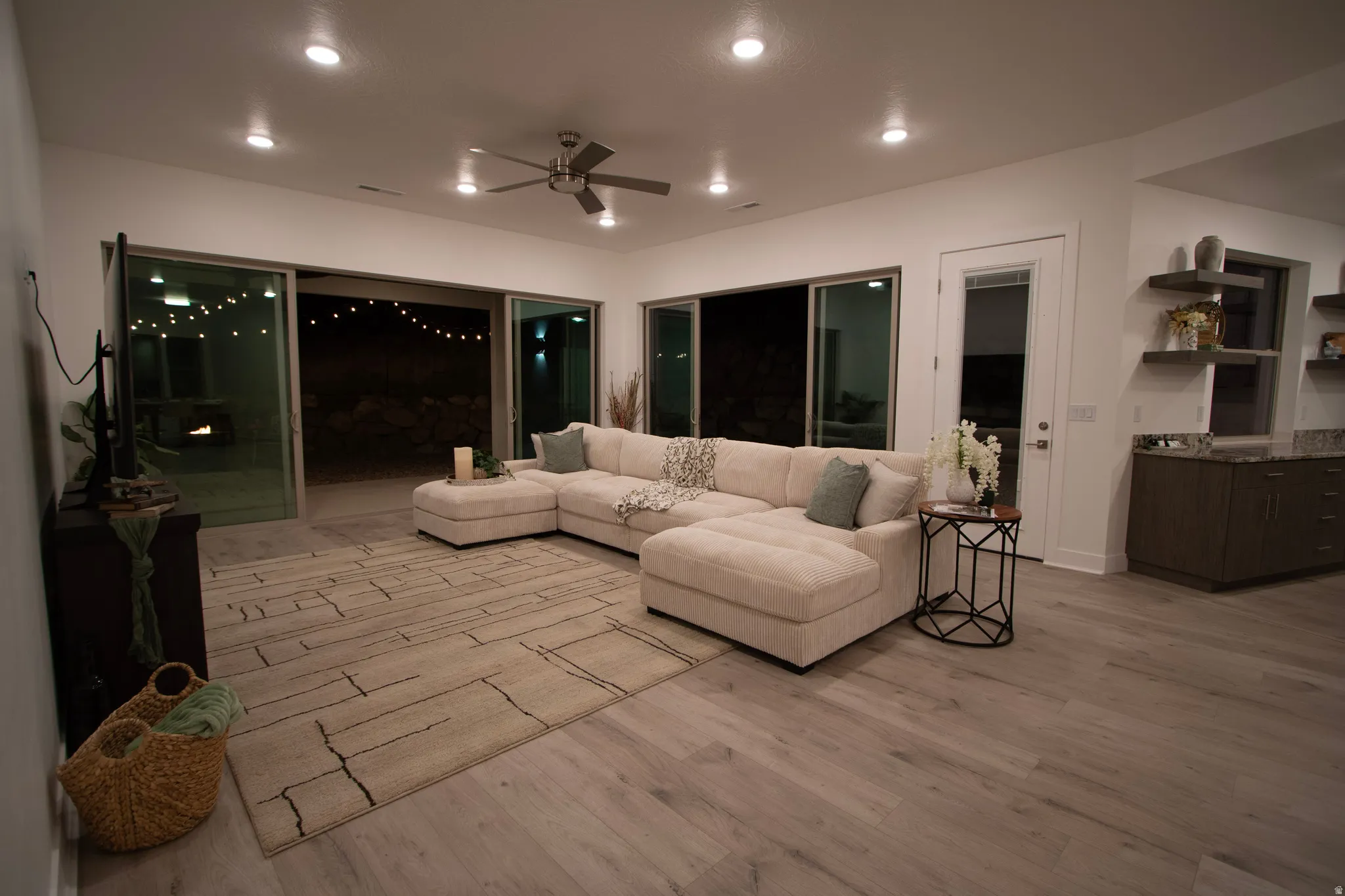 Spacious living area featuring wood-finish flooring, recessed lighting, and a ceiling fan