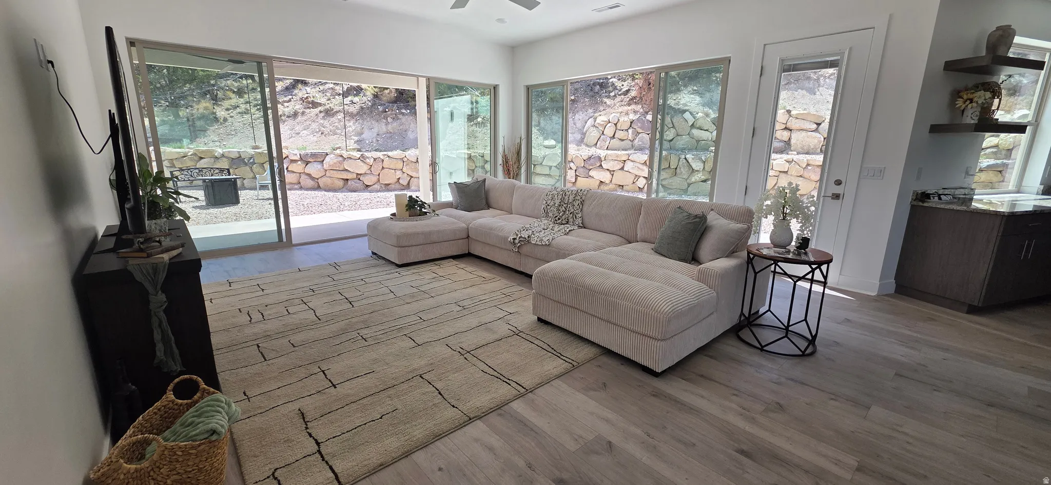 Spacious living area featuring light wood-finish flooring and large sliding glass doors