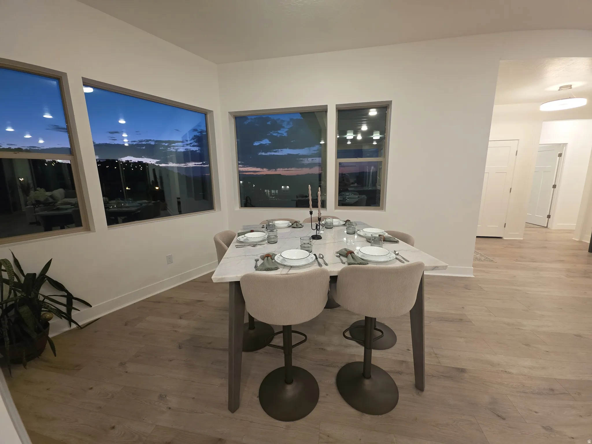 Dining area featuring light wood-finish flooring, white walls, and multiple windows