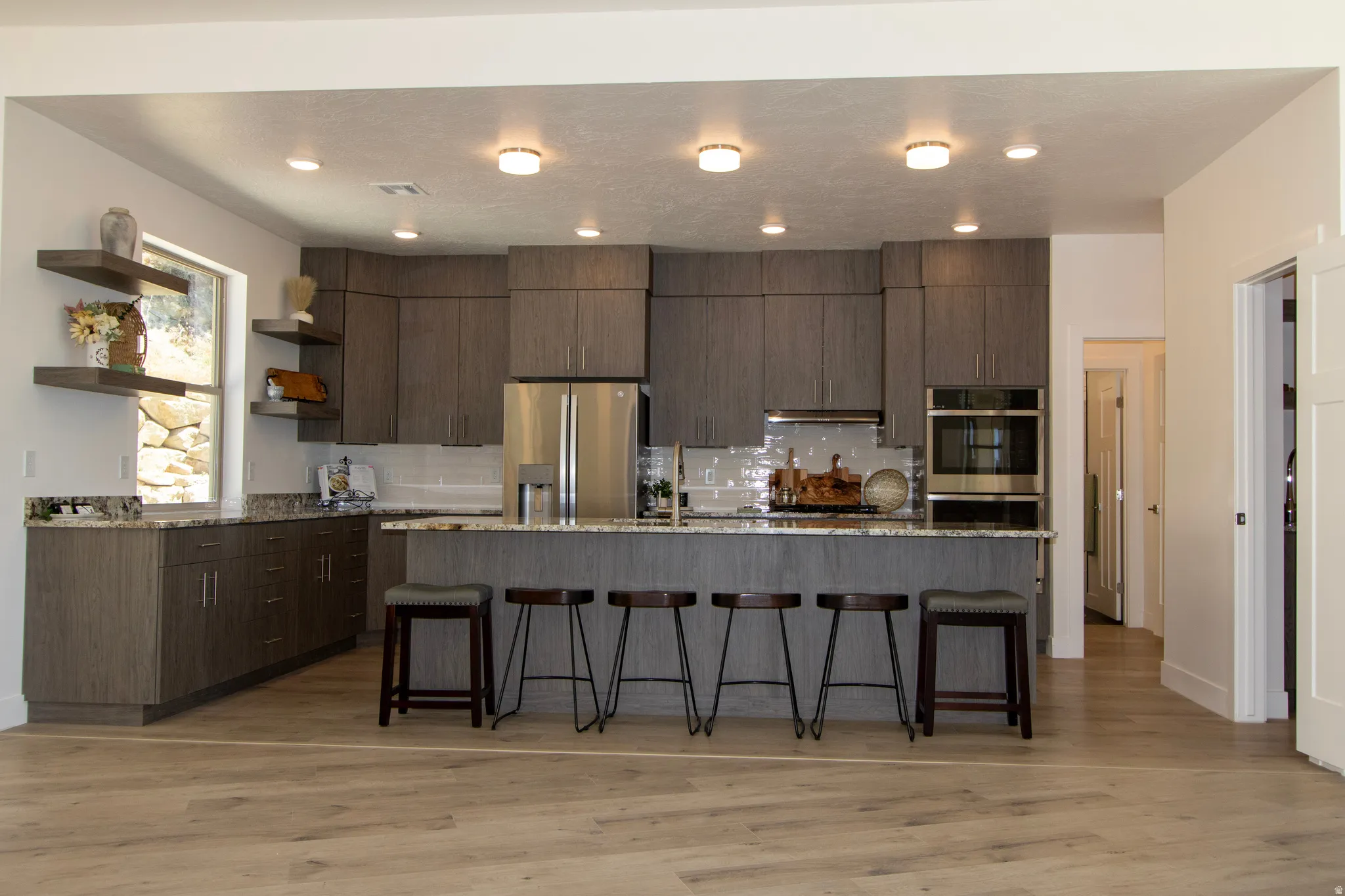 Contemporary kitchen featuring wood-finish cabinetry, granite countertops, and stainless steel appliances