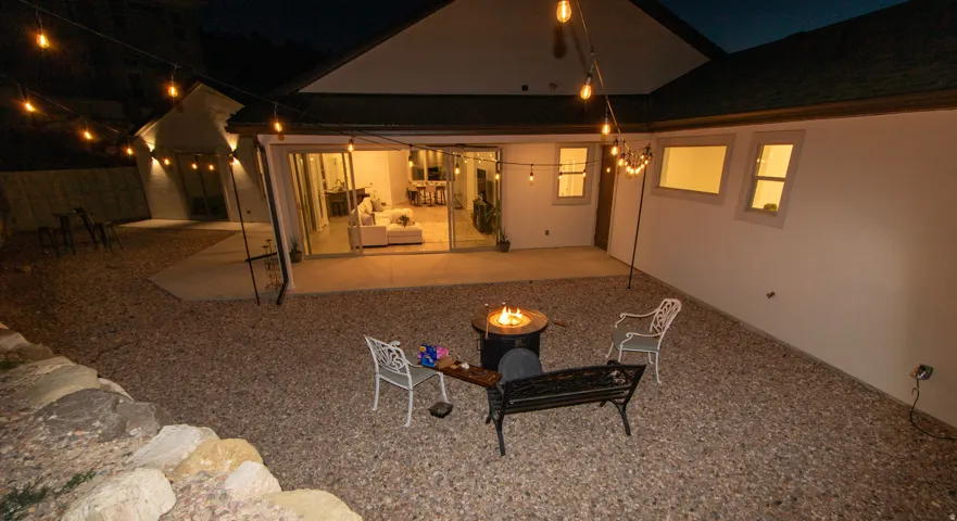 Private courtyard featuring a gravel ground cover, concrete patio, and string lighting