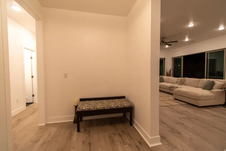 Open-concept living area with wood-finish flooring, recessed lighting, and a ceiling fan