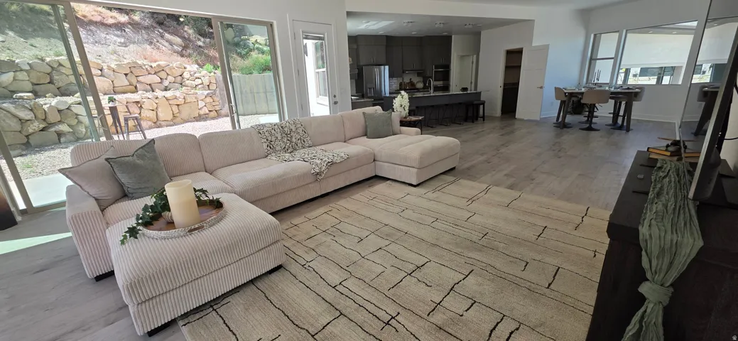 Open-concept living space featuring wood-finish flooring and large sliding glass doors