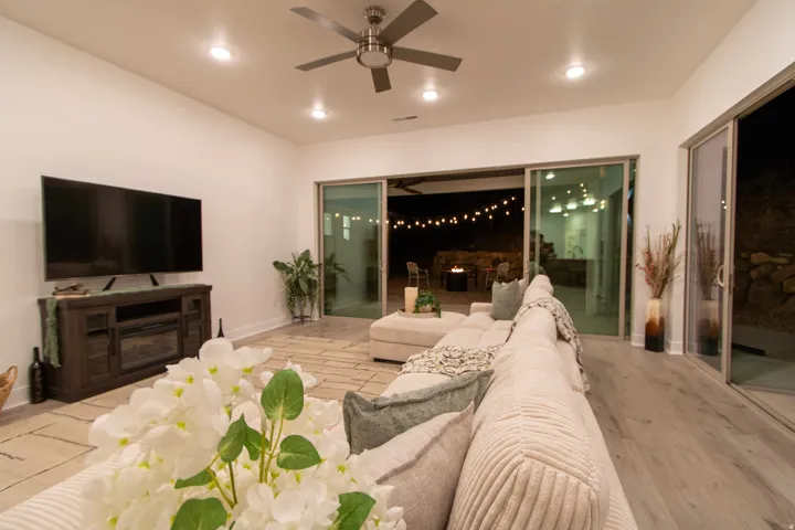 Open-concept living area with recessed lighting and a ceiling fan, featuring a media console with a built-in electric fireplace