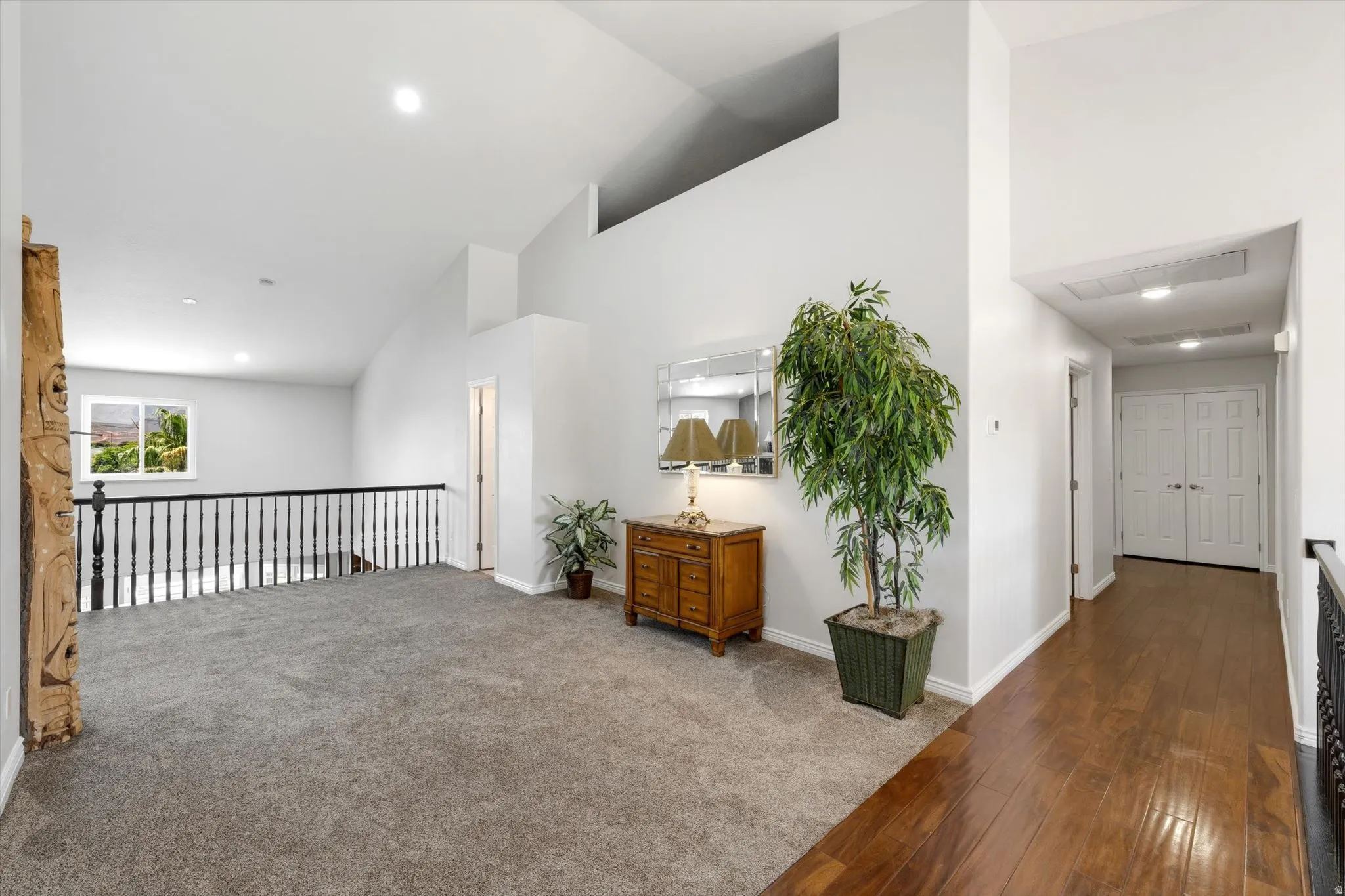 Open loft area featuring vaulted ceilings and a window