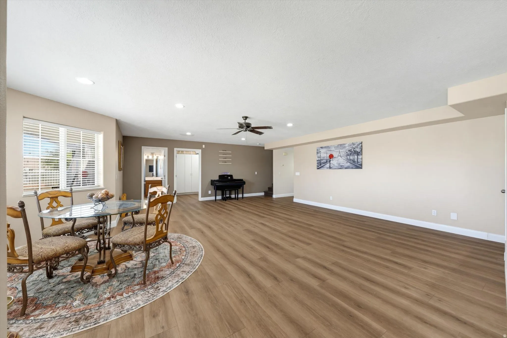 Open-concept living space featuring wood-finish flooring, recessed lighting, and a ceiling fan