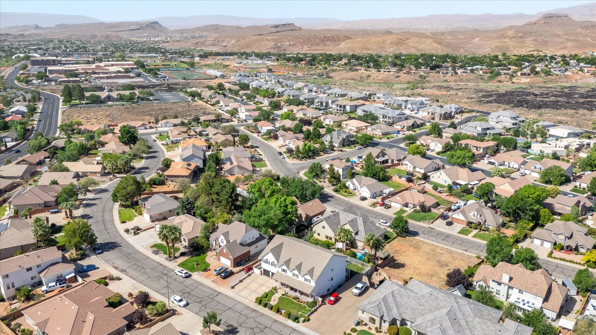Residential neighborhood featuring established homes with diverse architectural styles, mature landscaping, and paved streets