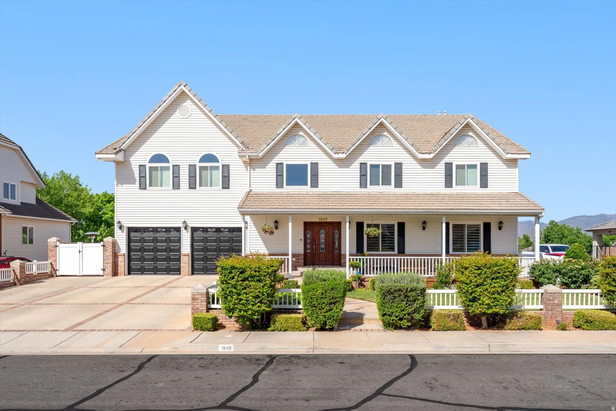 Traditional white siding exterior with a covered porch featuring white railing and columns