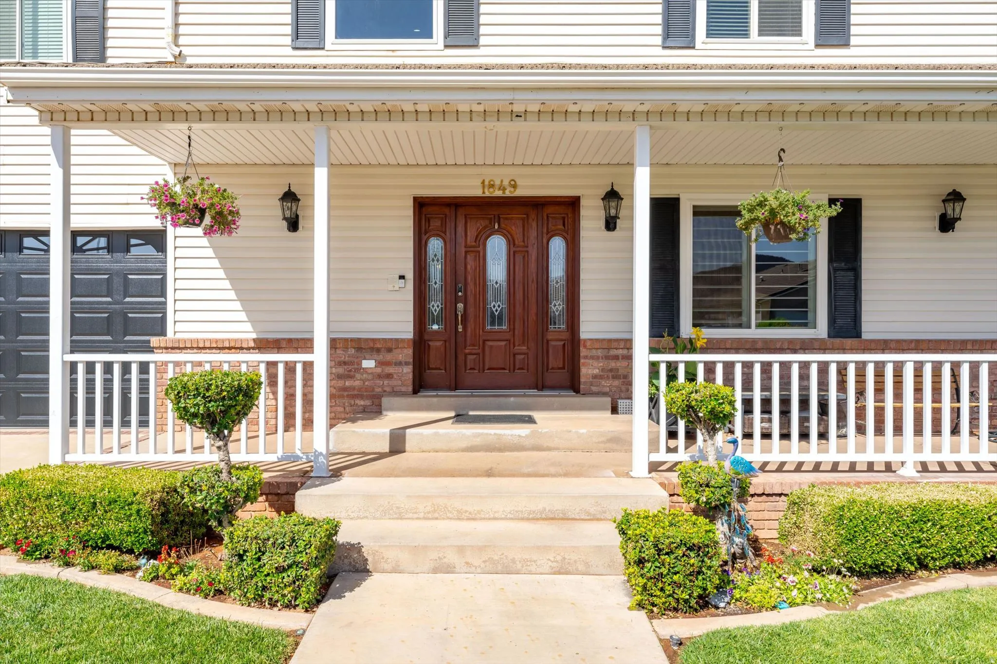 Entryway featuring a wood double door, a covered porch with white columns, and concrete steps
