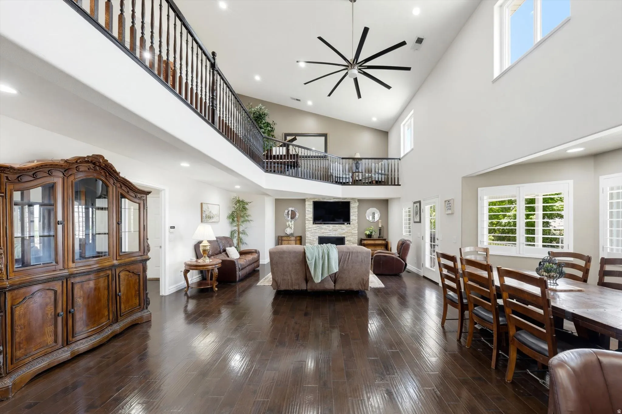 Spacious interior featuring high vaulted ceilings, rich wood-finish flooring, and a second-story balcony overlooking the main living area