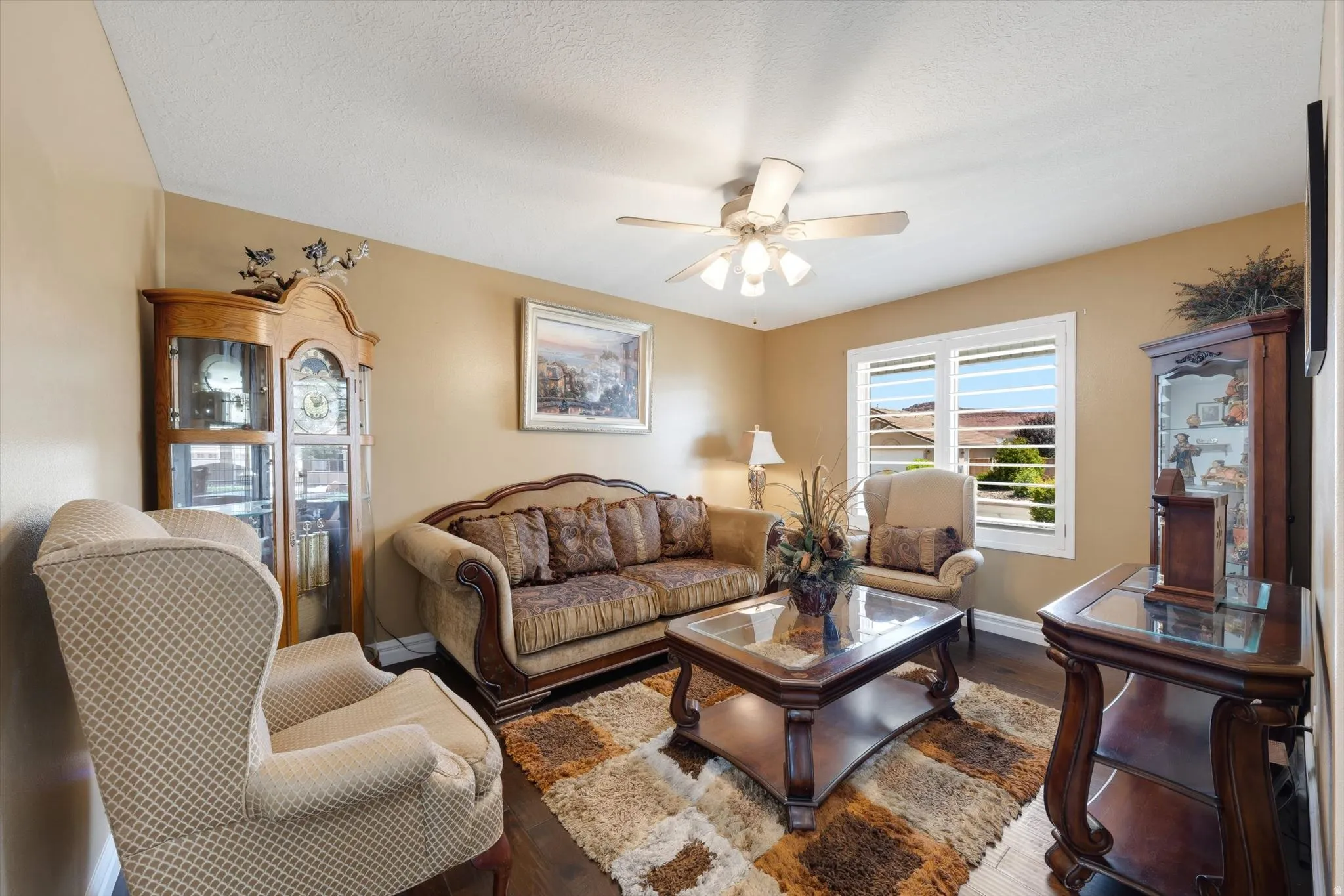 Living area with wood-finish flooring and a ceiling fan
