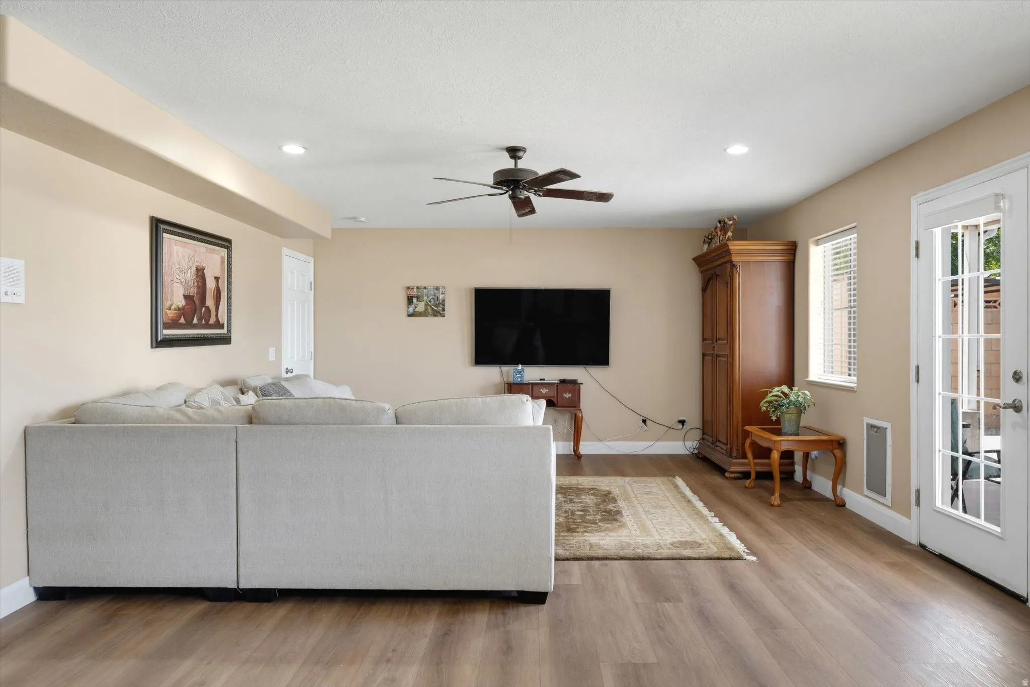 Living area featuring wood-finish flooring, recessed lighting, and a ceiling fan