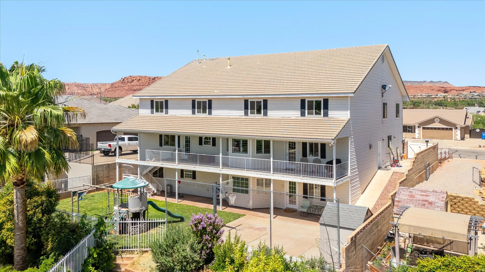 Three-story residence featuring light-colored siding, a multi-tier balcony system with white railings, and a light-toned roof