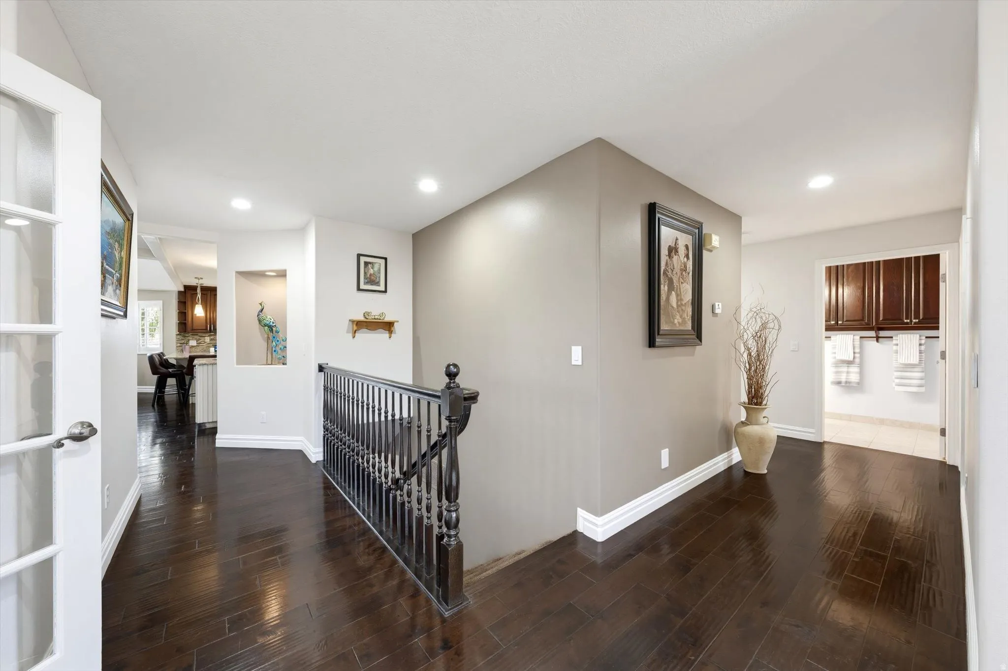Dark wood-finish flooring throughout, featuring a staircase with black balusters and railing