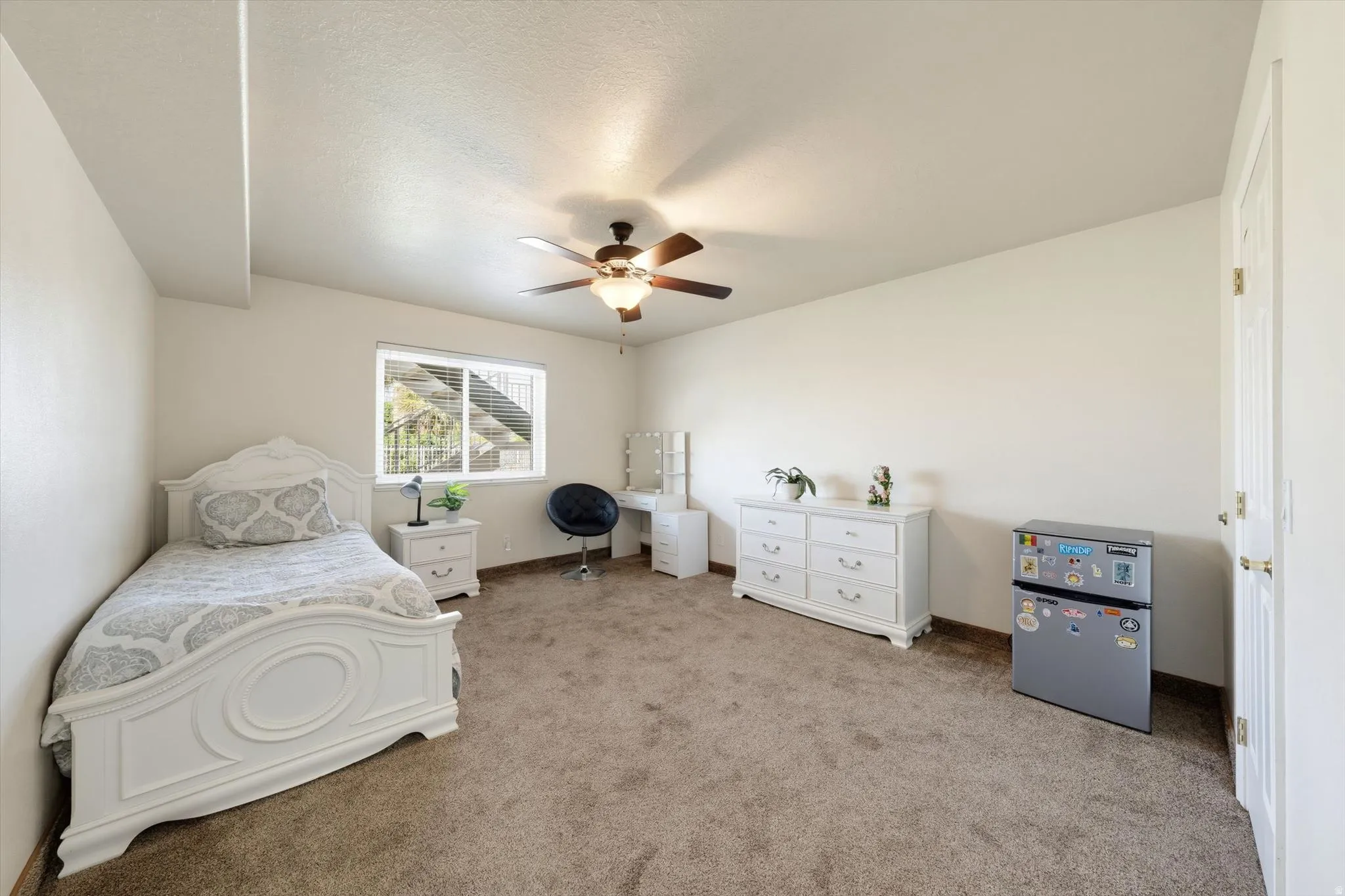 Spacious interior room with neutral-toned carpet flooring and light-colored walls