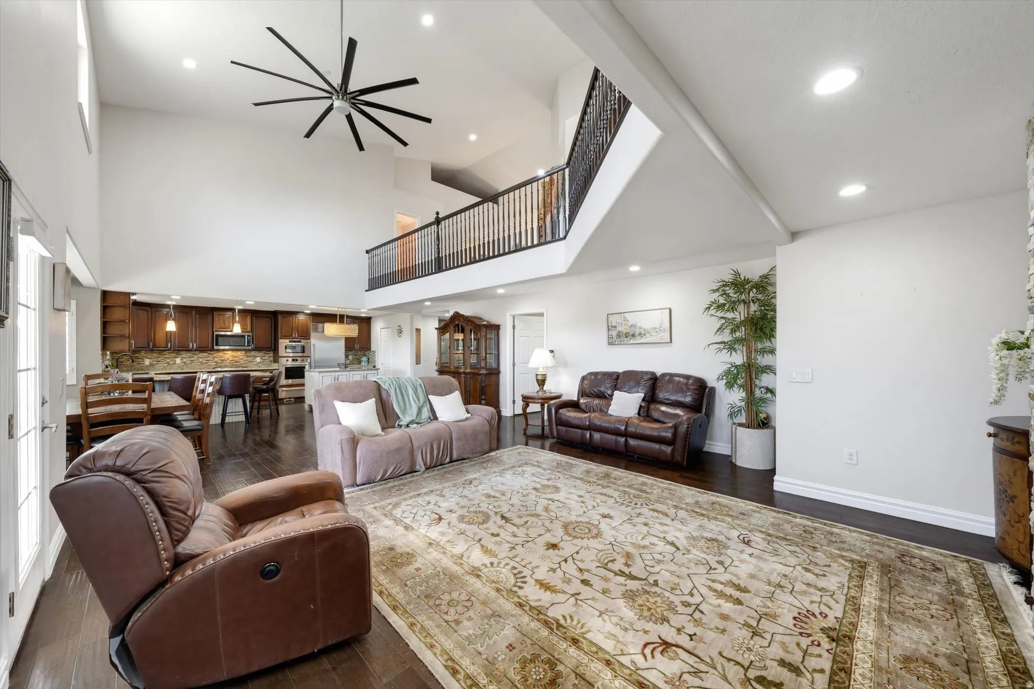 Vaulted great room featuring wood-finish flooring, a contemporary ceiling fan, and recessed lighting