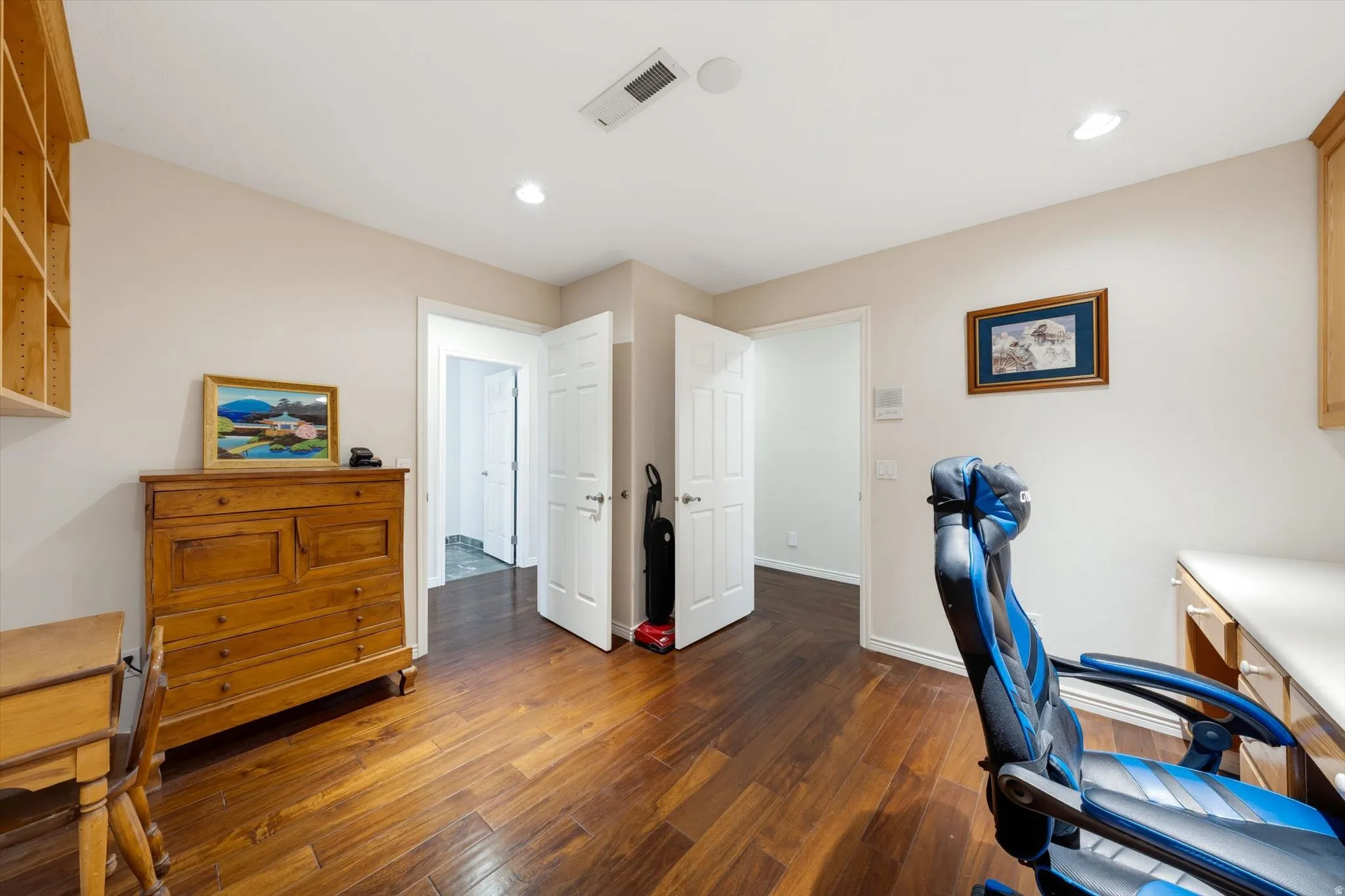 Hardwood-finish flooring throughout this room, featuring recessed lighting and built-in shelving
