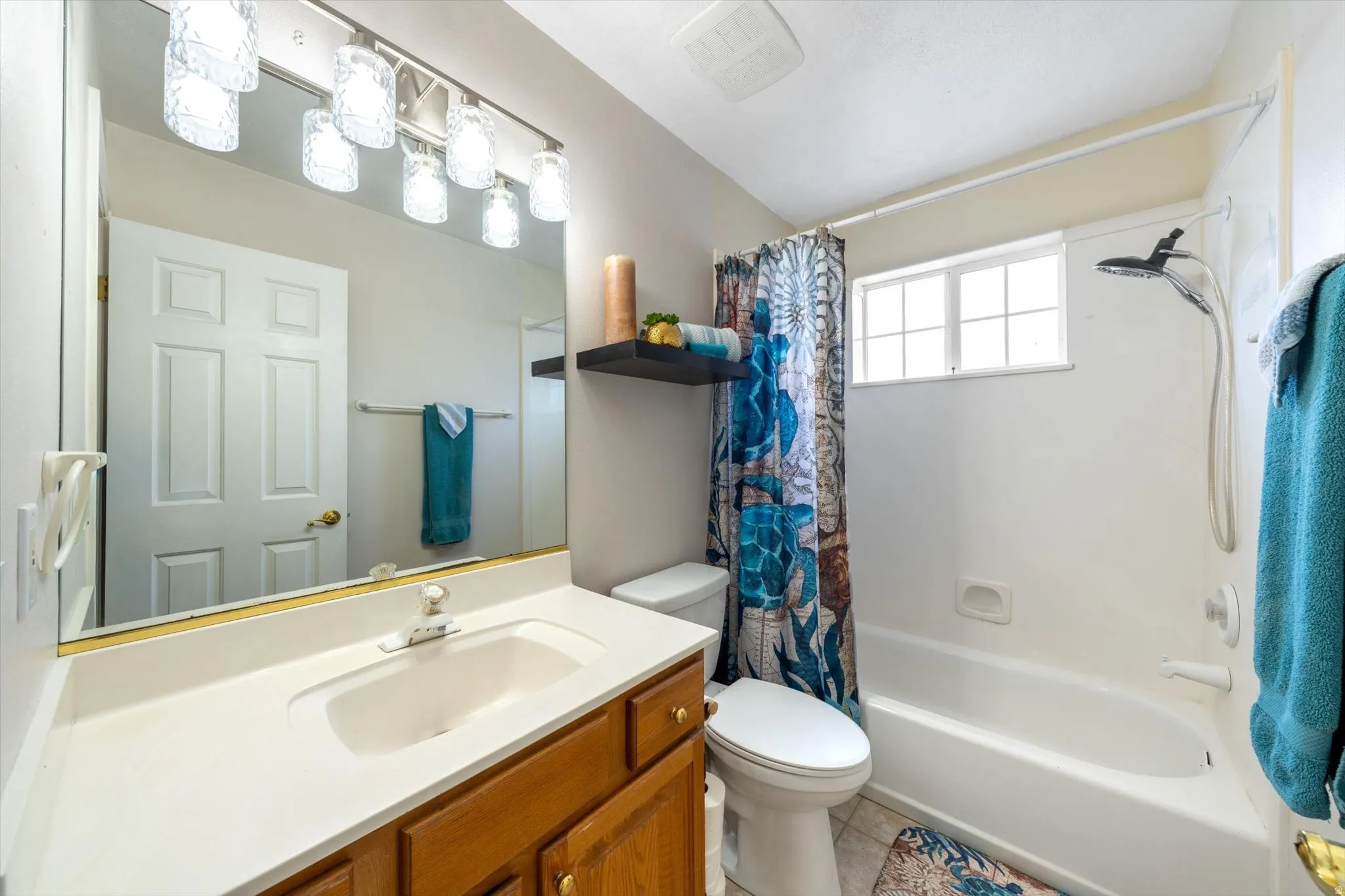 Bathroom featuring a single vanity with wood cabinetry, a white countertop, and a large mirror
