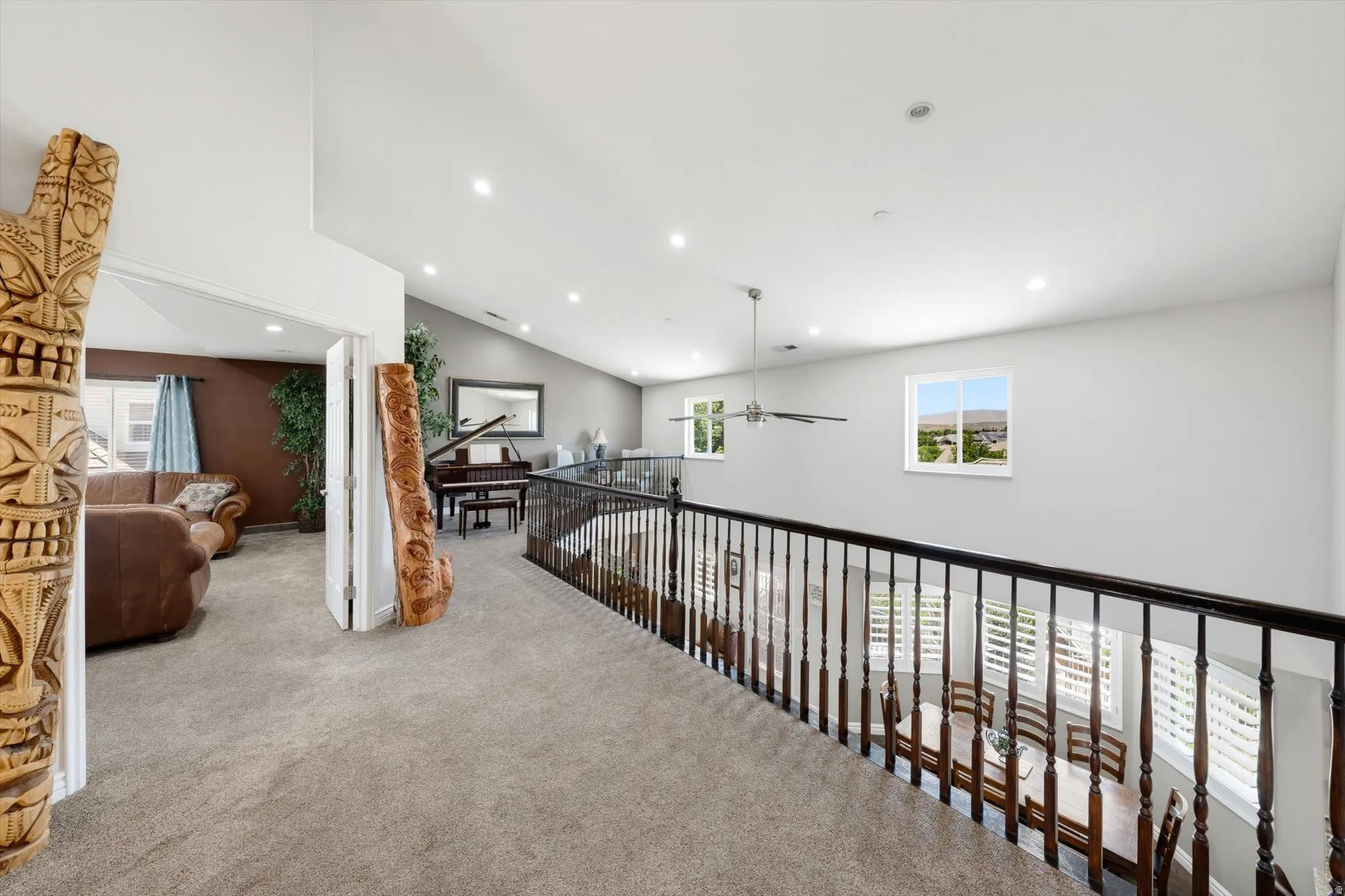 Spacious loft area featuring vaulted ceilings, recessed lighting, and soft carpet flooring