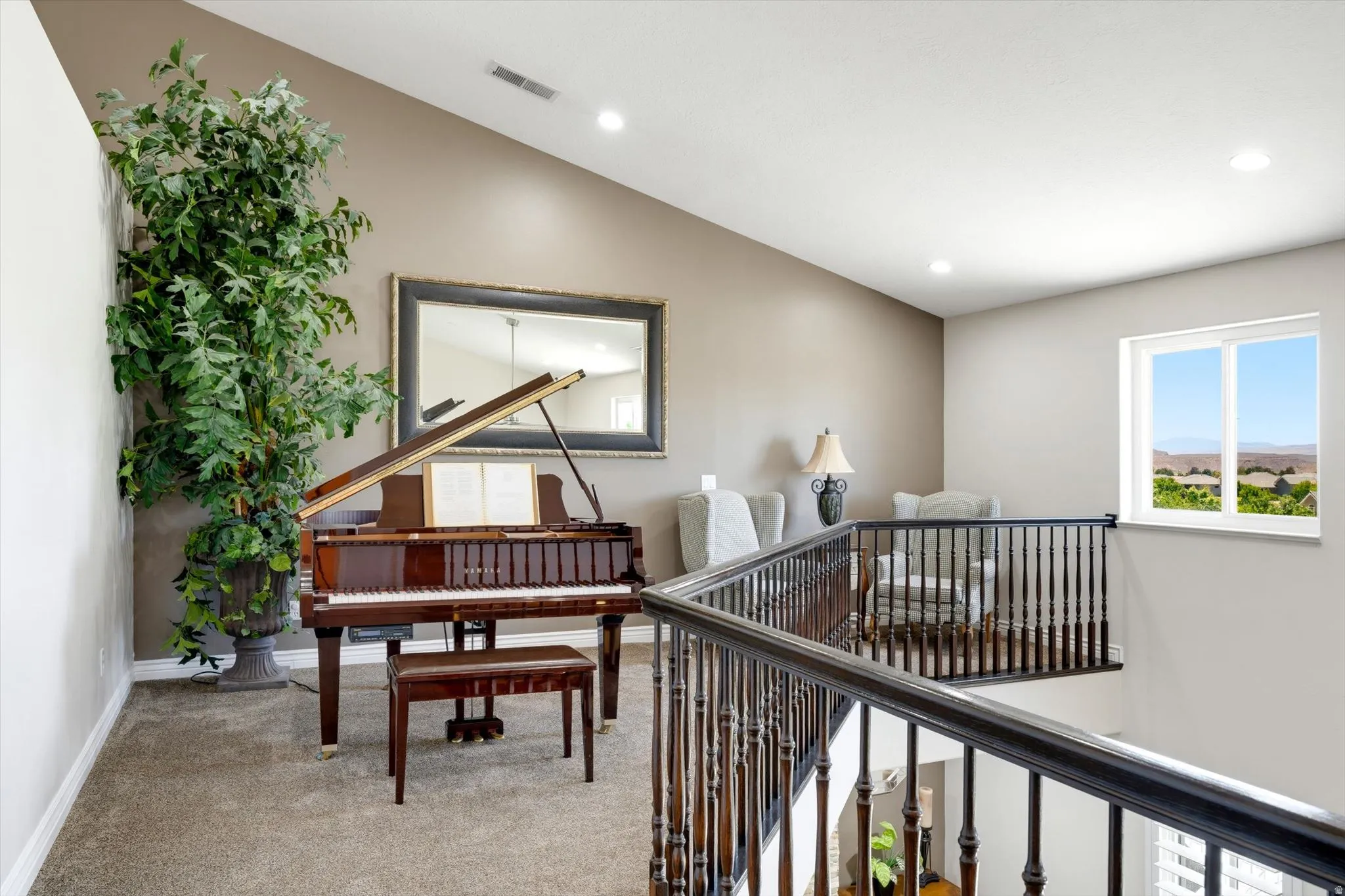 Open upper-level space featuring vaulted ceilings, recessed lighting, and neutral wall tones