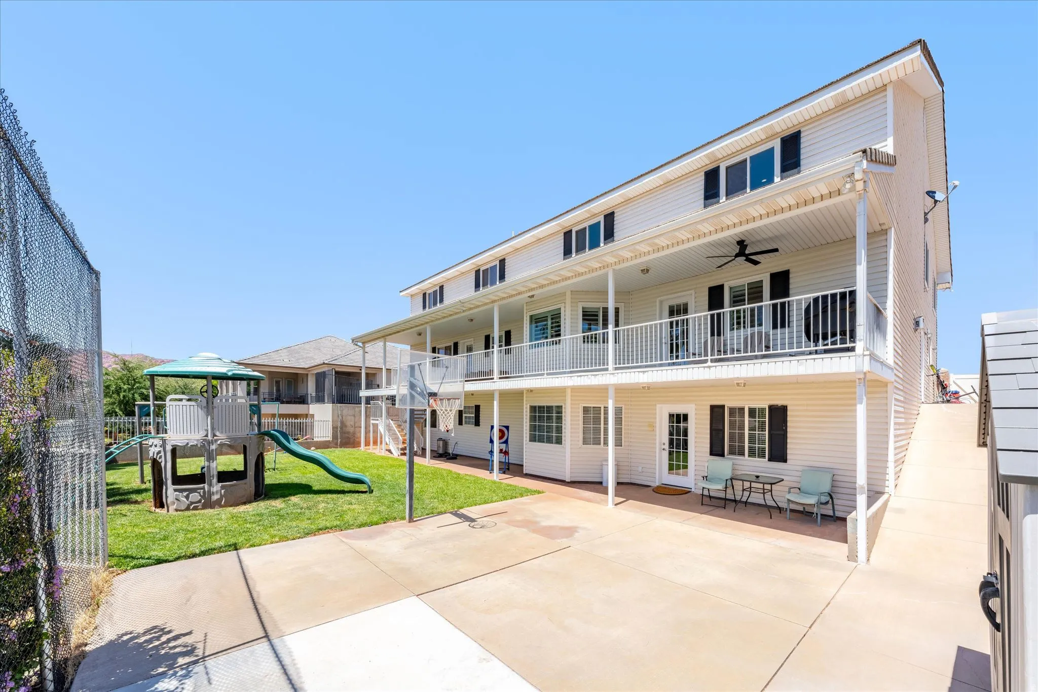 Multi-level exterior featuring white siding and black shutters